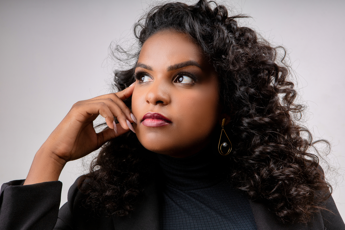 nail designer com mão no rosto olhando pro lado