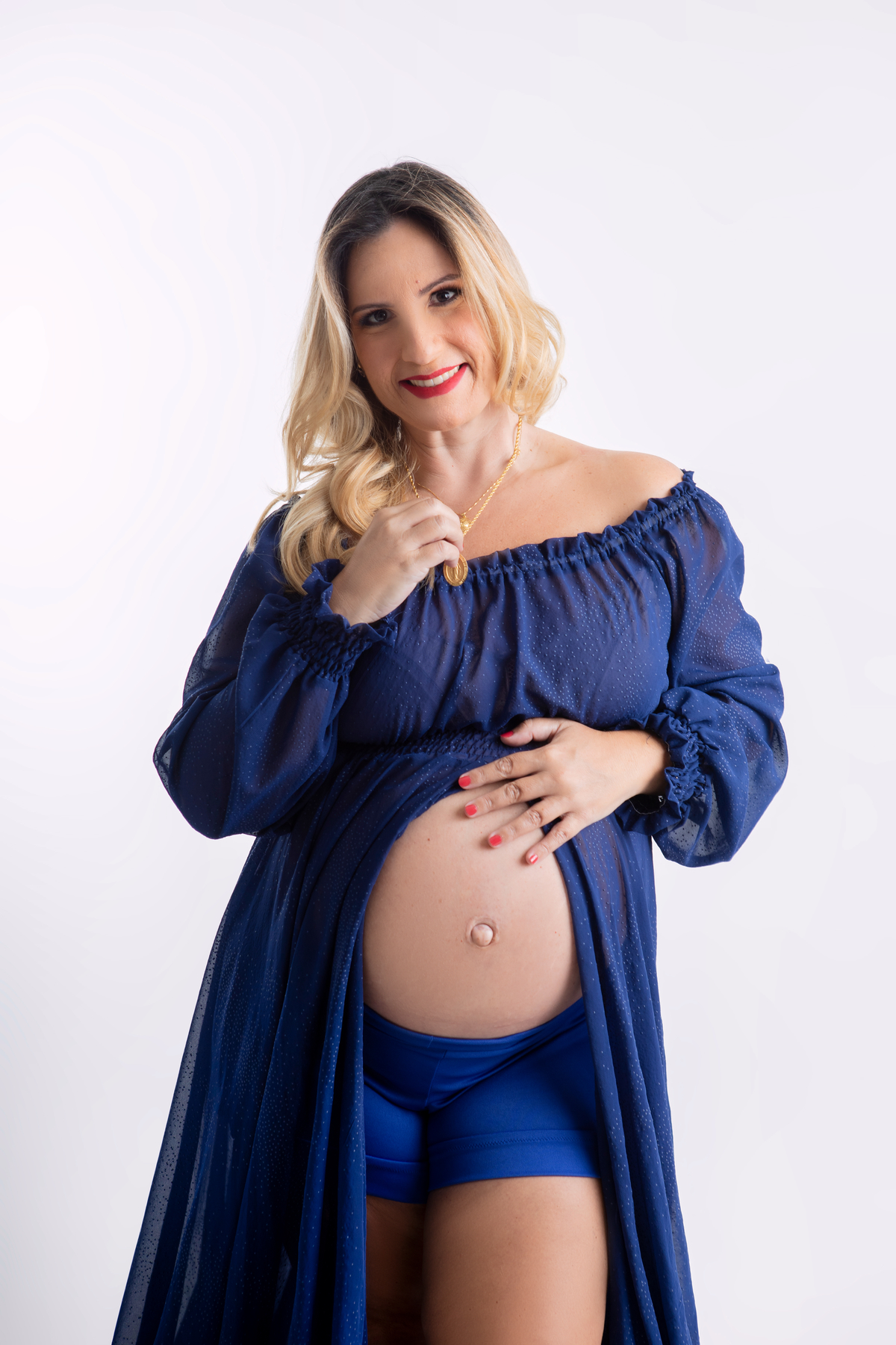 gestante com mão na barriga e outra no colar