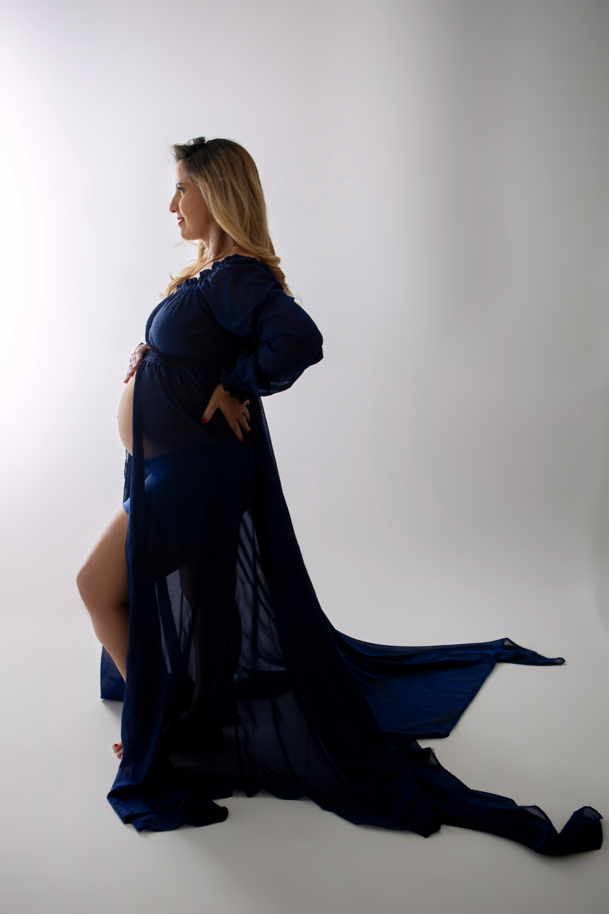 gestante com mão na barriga e outra na cintura 