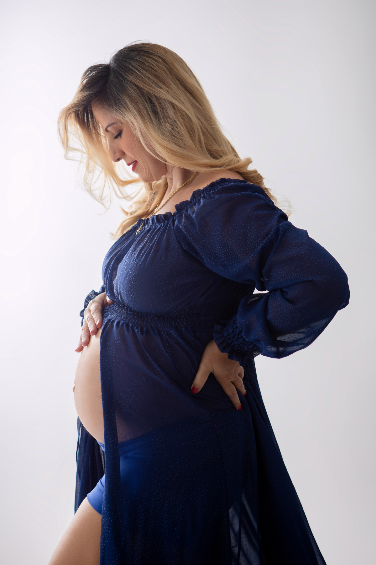 gestante com mão na barriga e outra na cintura 