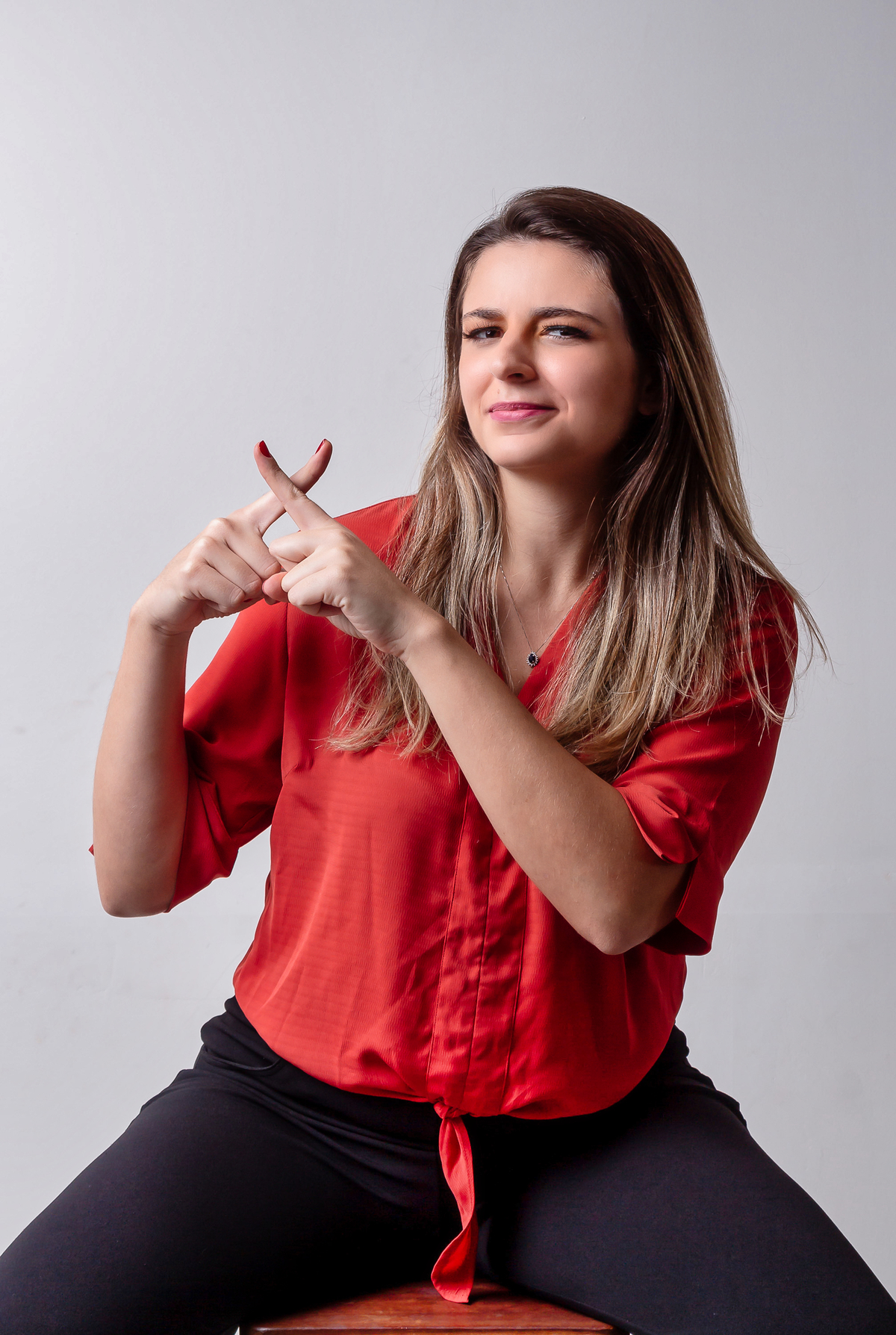 apontando pra cima fazendo sinal de X