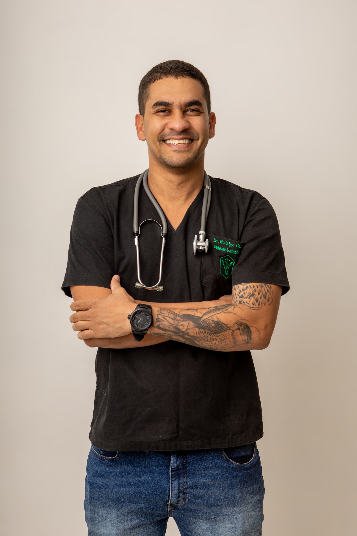 médico veterinário com braços cruzados e usando estetoscópio no pescoço