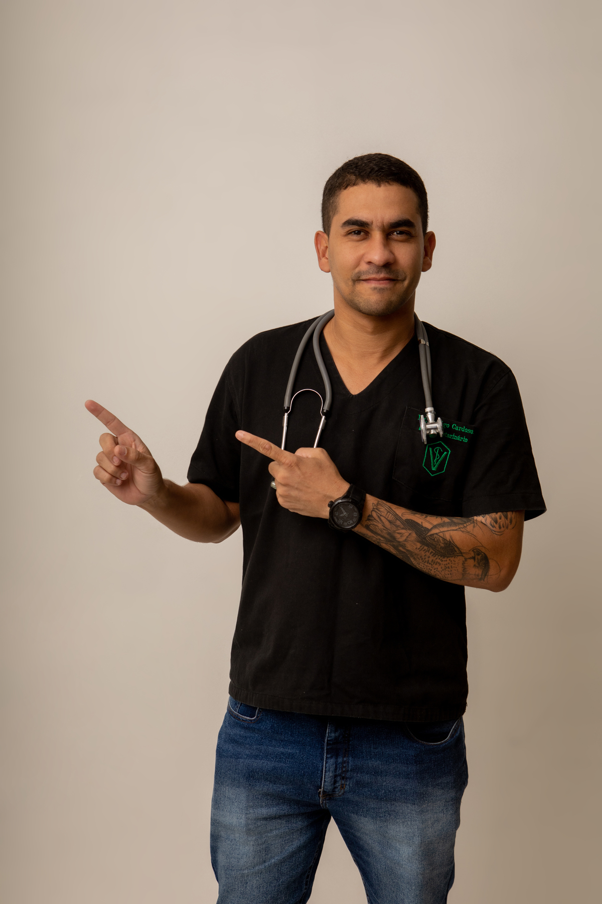 médico veterinário apontando pro lado e usando estetoscópio no pescoço