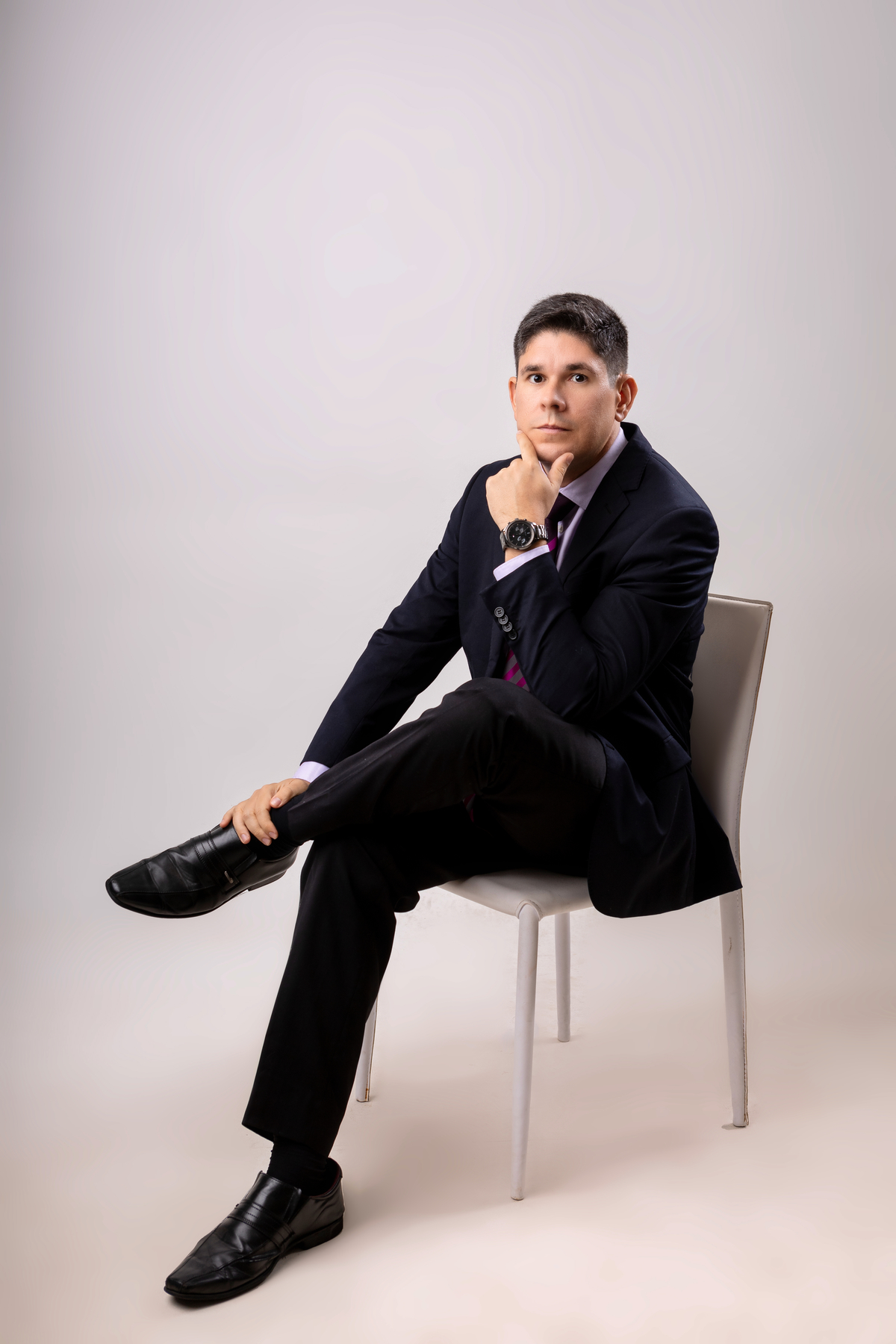 advogado sentado com mão no tornozelo e braço cruzado