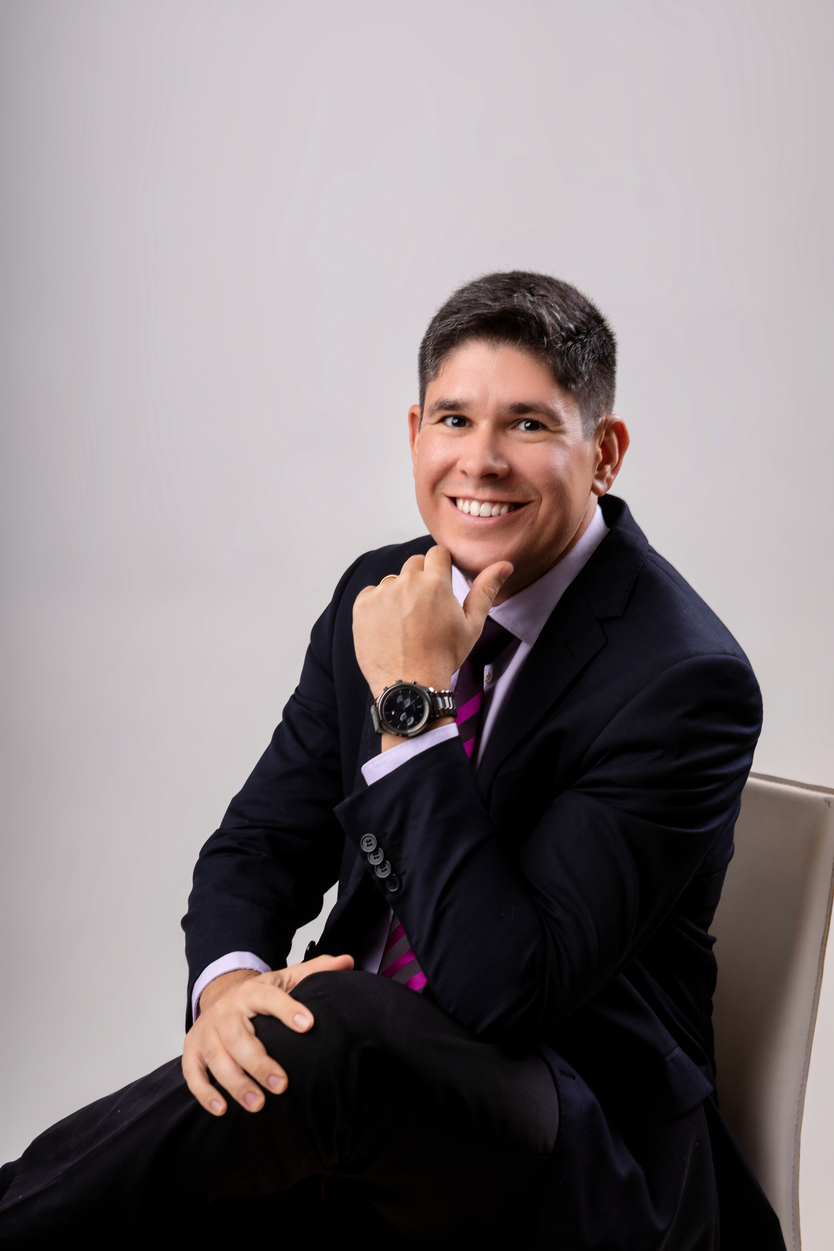 advogado sentado com mão na canela e braço cruzado