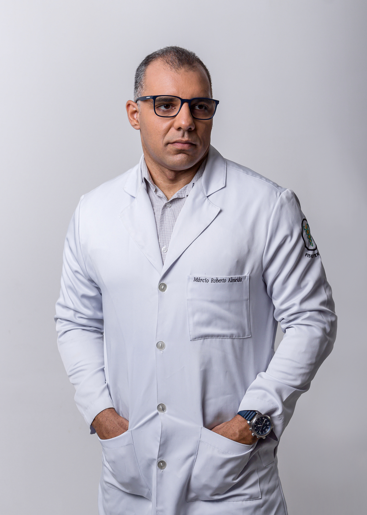 fisioterapeuta com jaleco com mãos no bolso