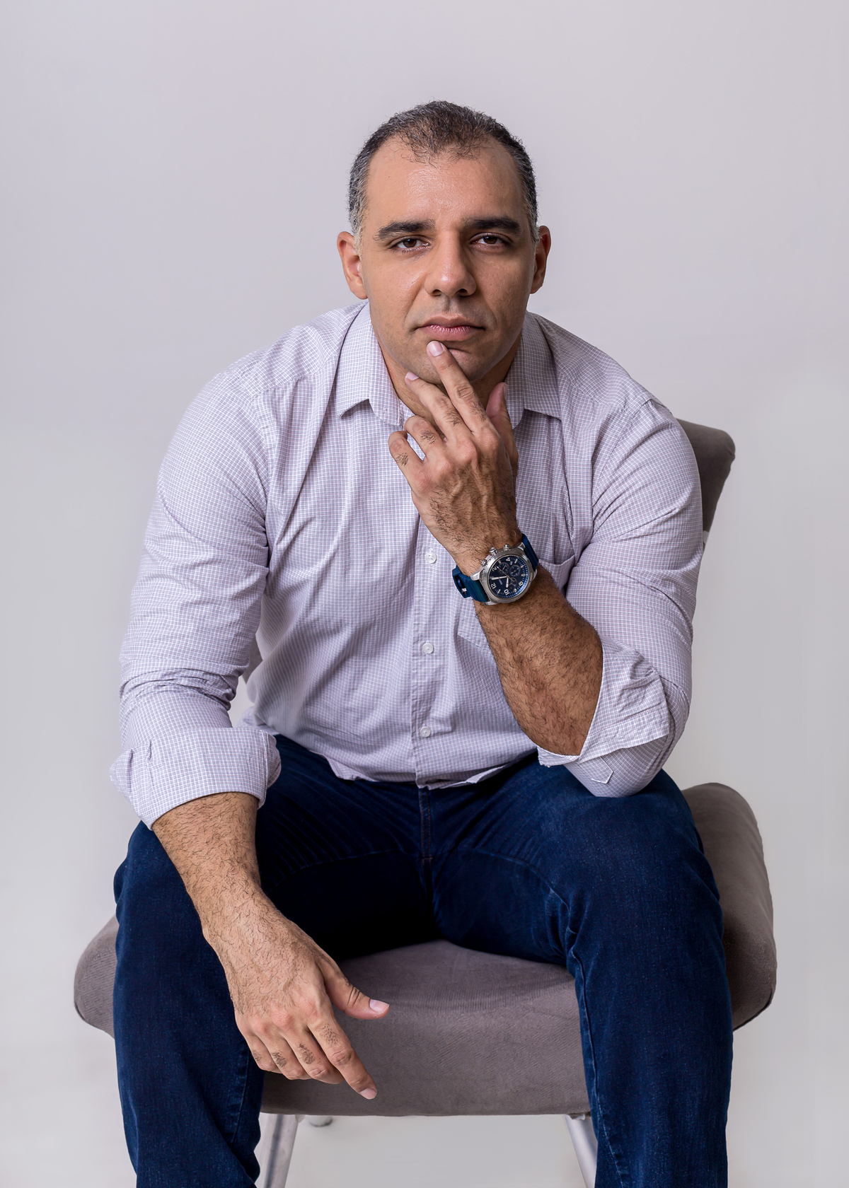 fisioterapeuta sentado na cadeira com mão no queixo