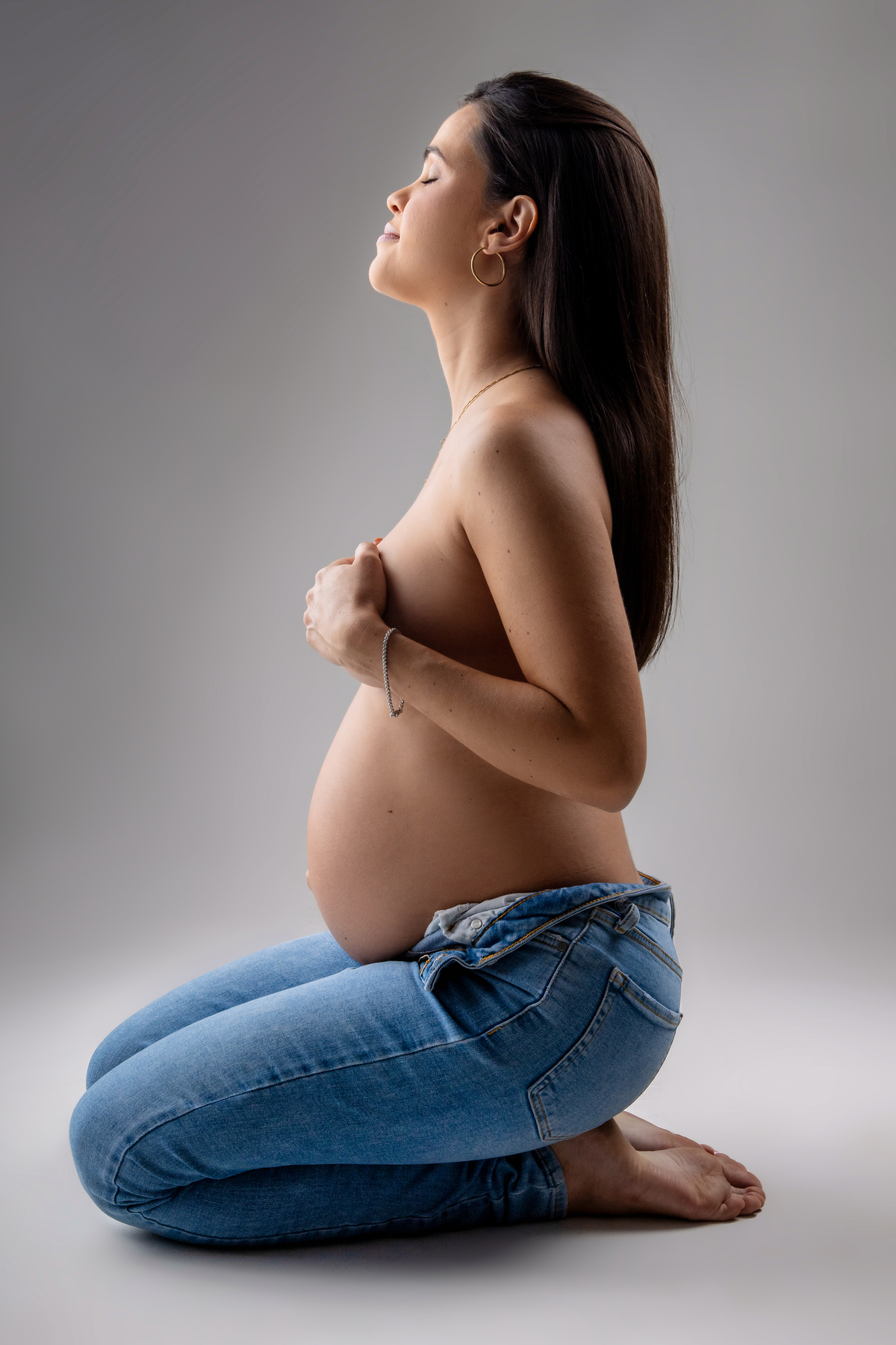 gestante de calça com mãos nos seios