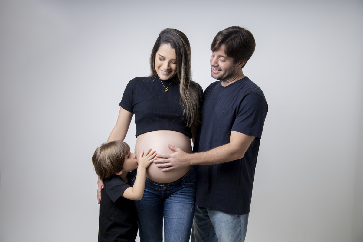 papai e mamãe gestante vendo seu filho beijar a barriga