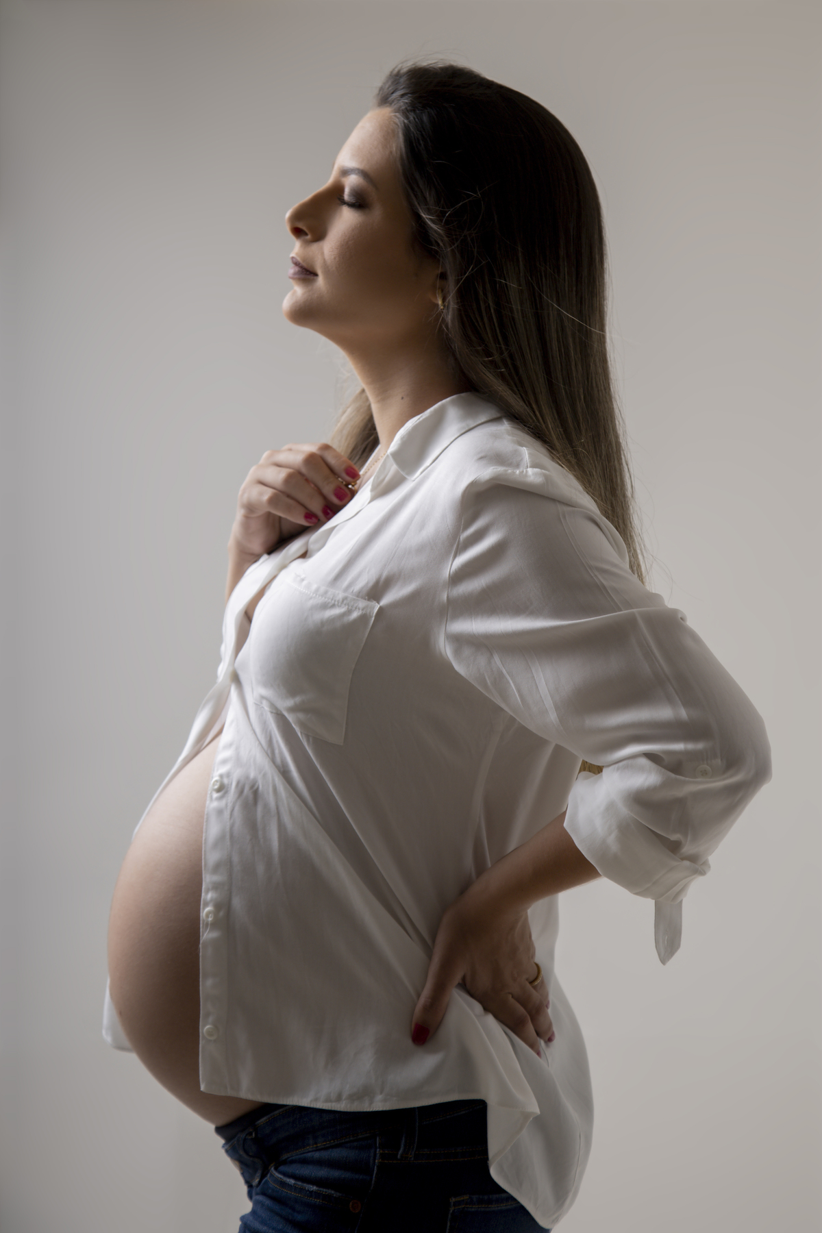 gestante com mão no colar e outra na cintura