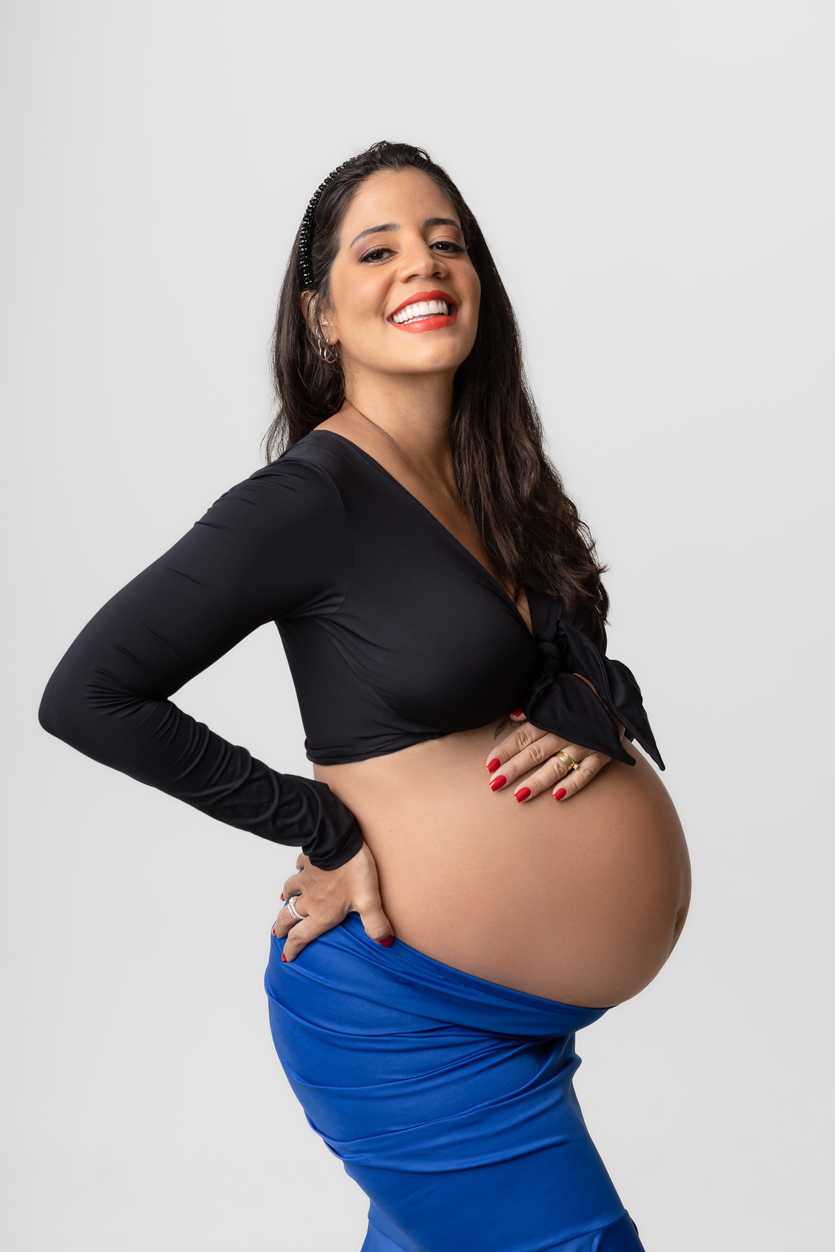 gestante com mão na barriga e outra na cintura