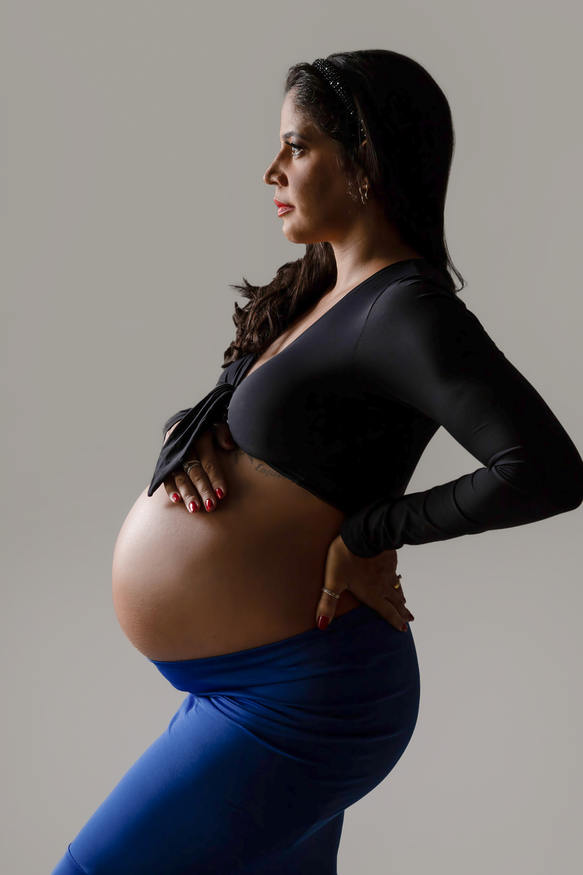 gestante com mão na barriga e outra na cintura