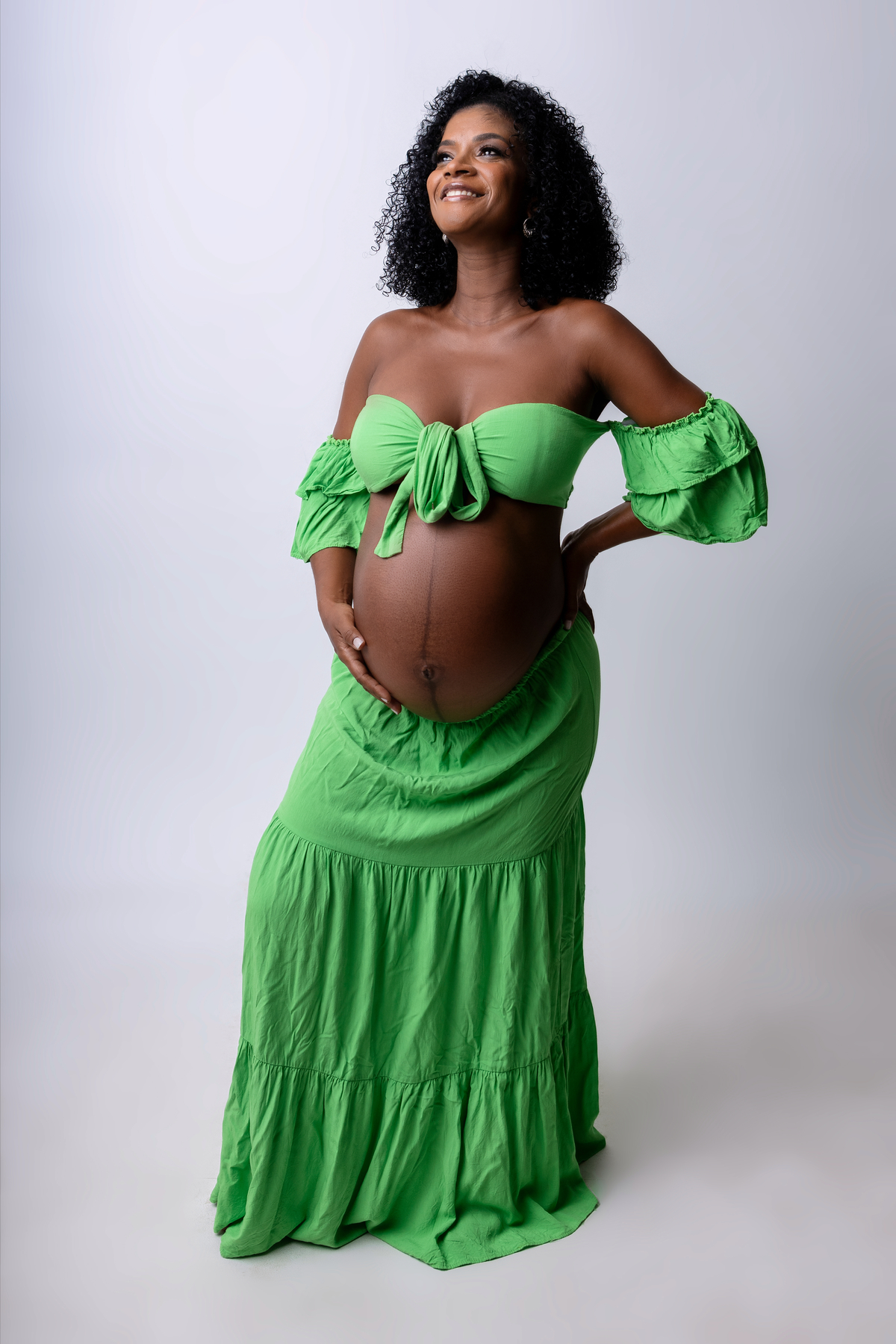 gestante com mão na barriga e outra na cintura 