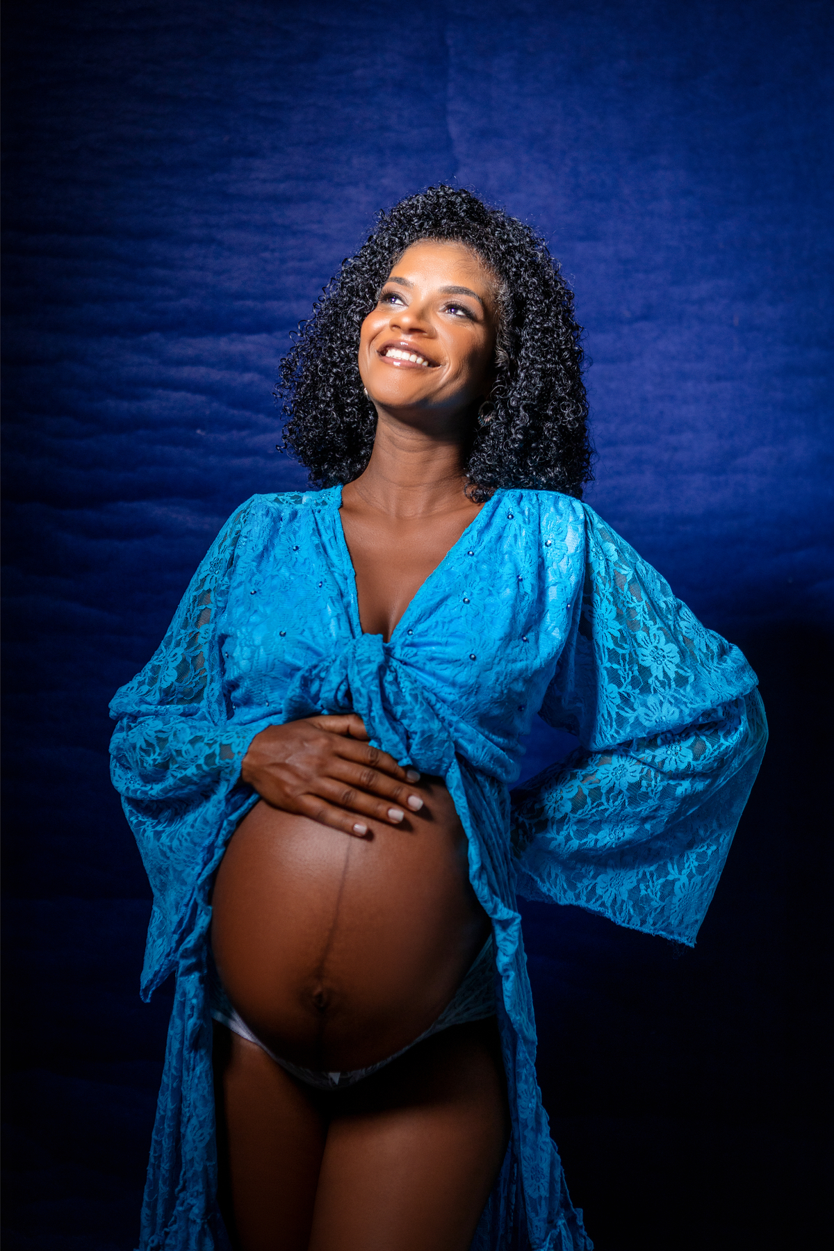 gestante com mão na barriga e outra na cintura 