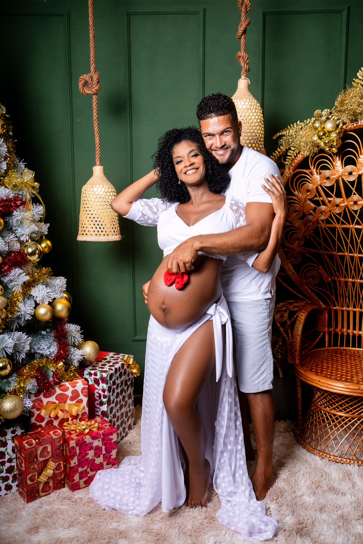 papai segurando o sapatinho do bebê na barriga da gestante