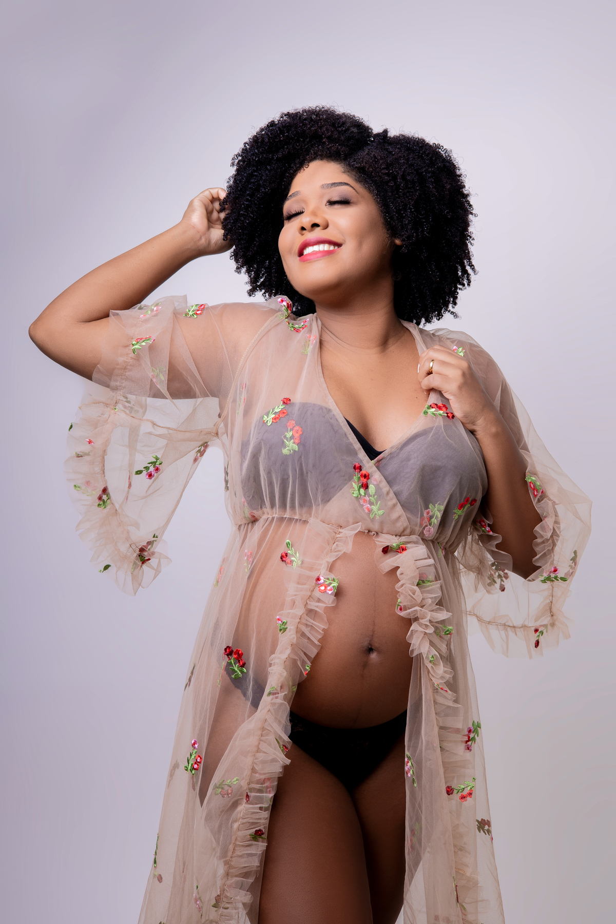 gestante com mão no cabelo e segurando vestido