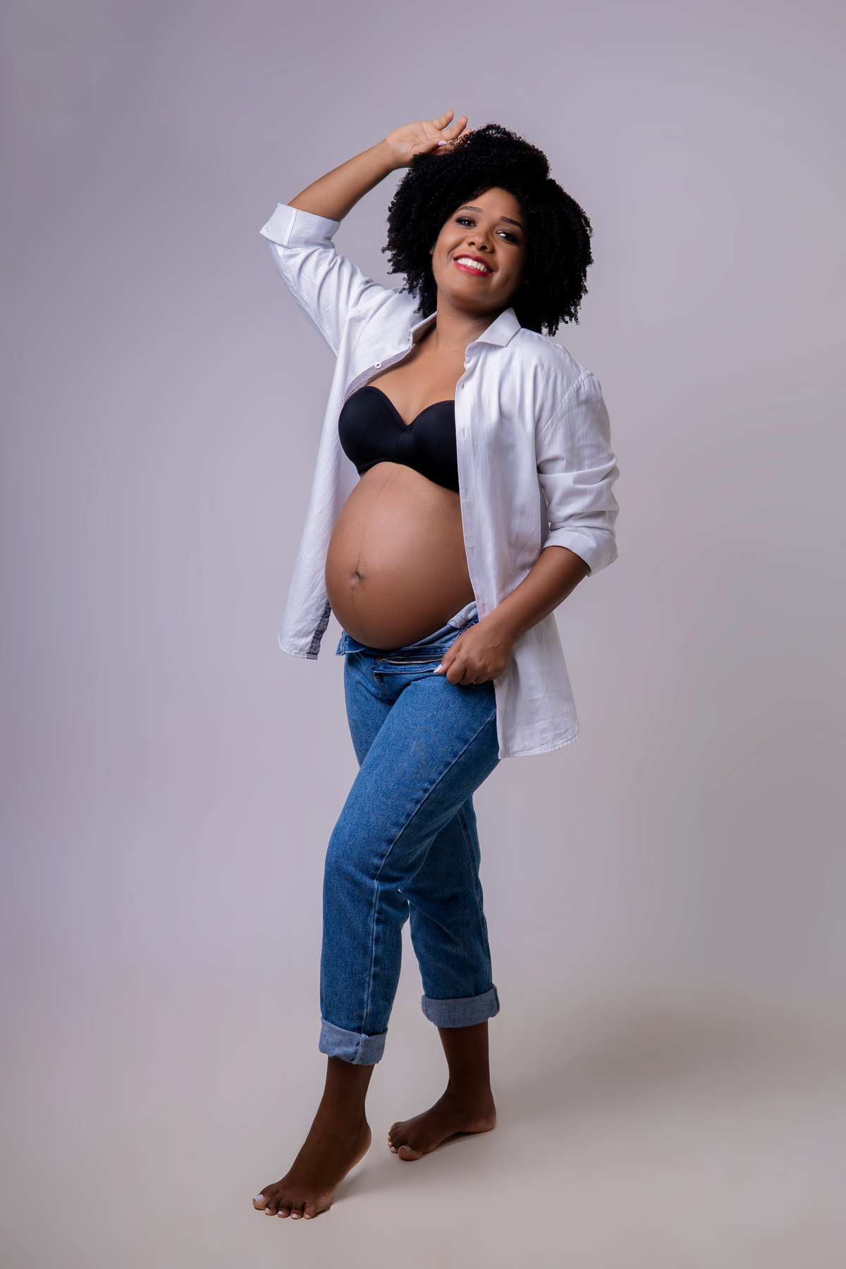 gestante segurando a calça e outra mão no cabelo