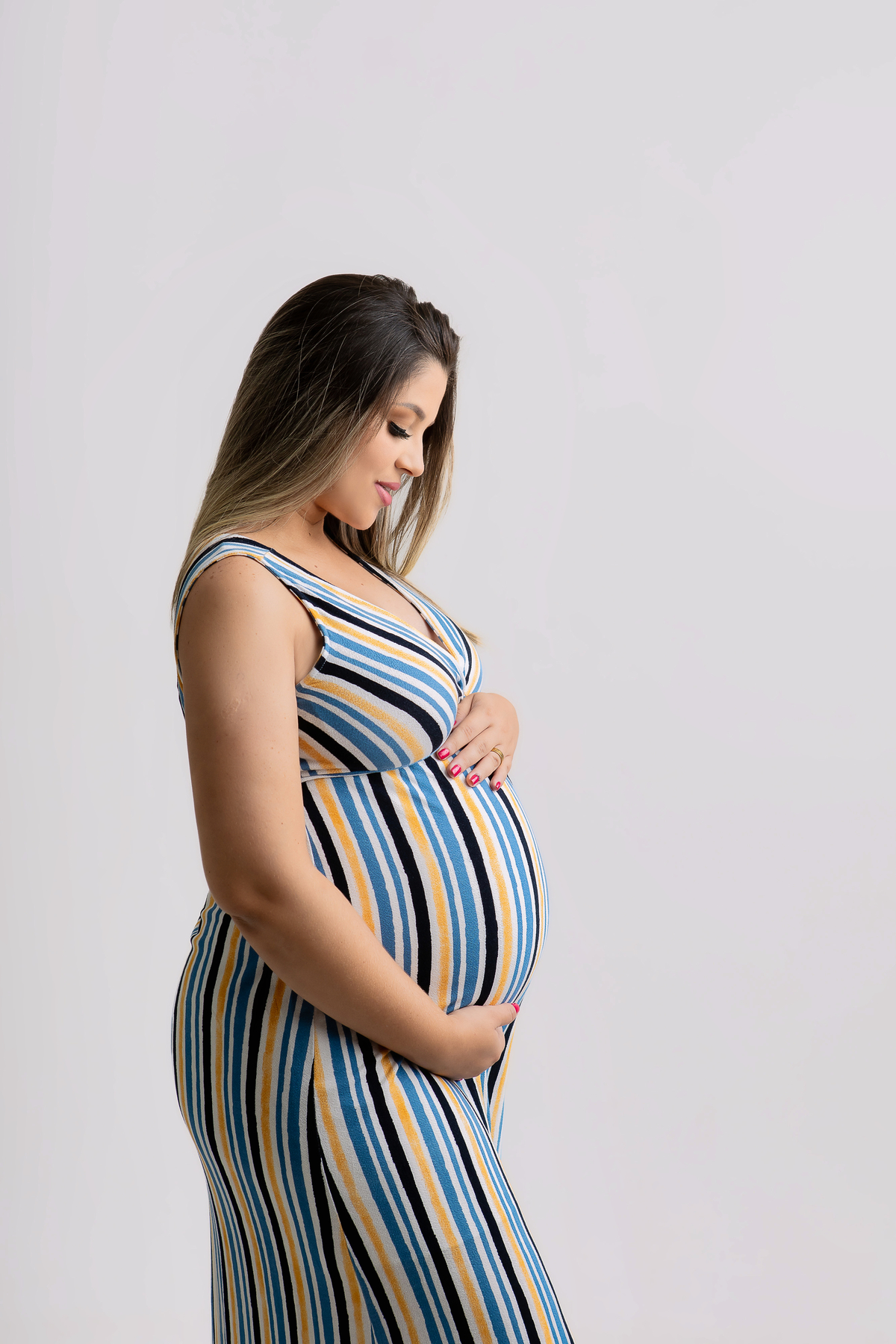 gestante olhando e abraçando a barriga