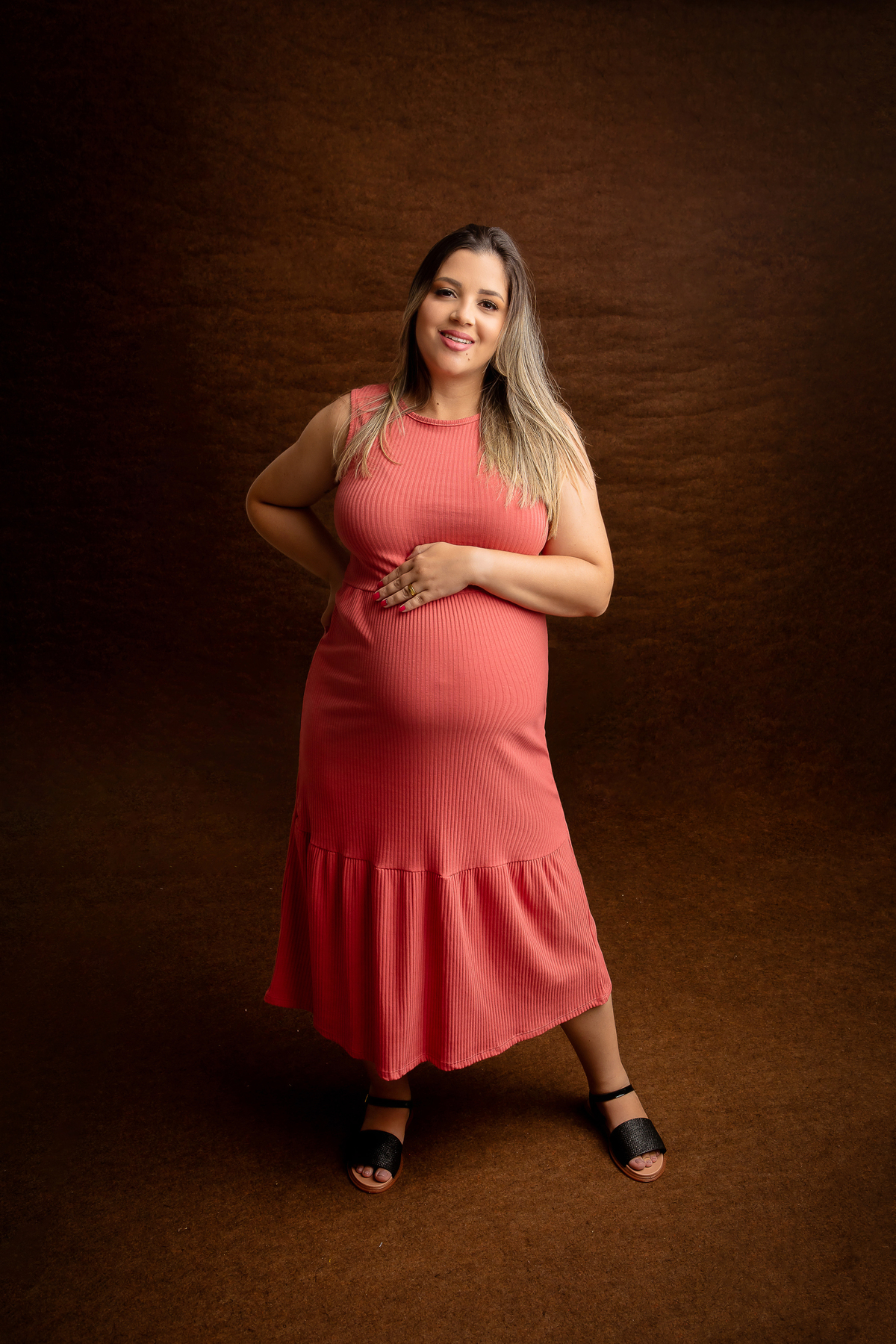 gestante com mão na cintura e outra na barriga