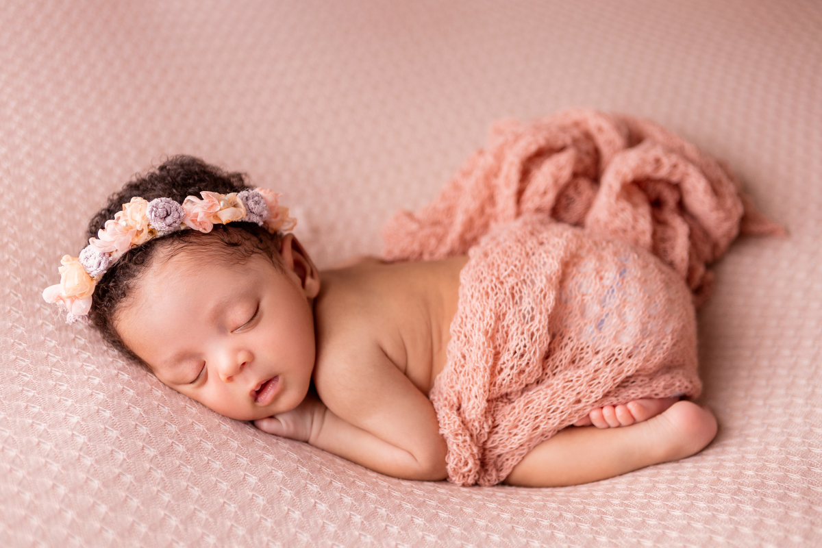 newborn de bruços com tiara