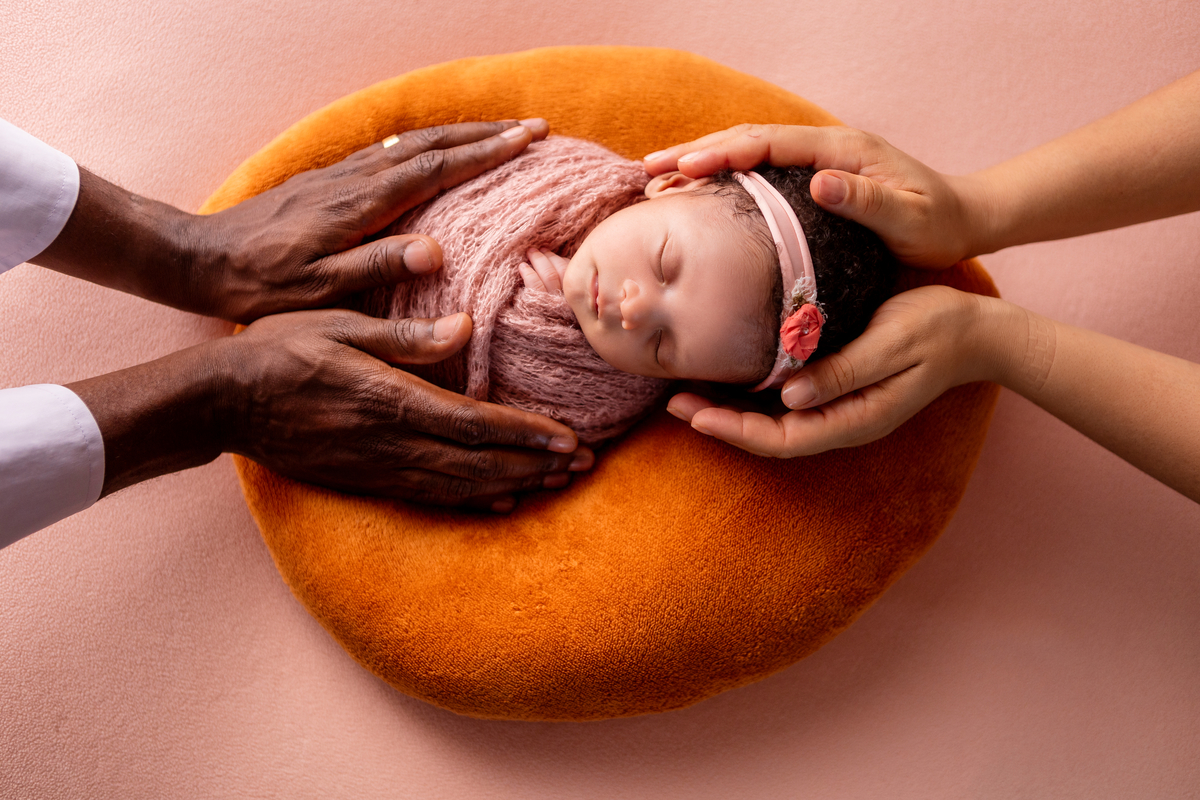 wrap newborn rosa com as mãos de papai e mamãe
