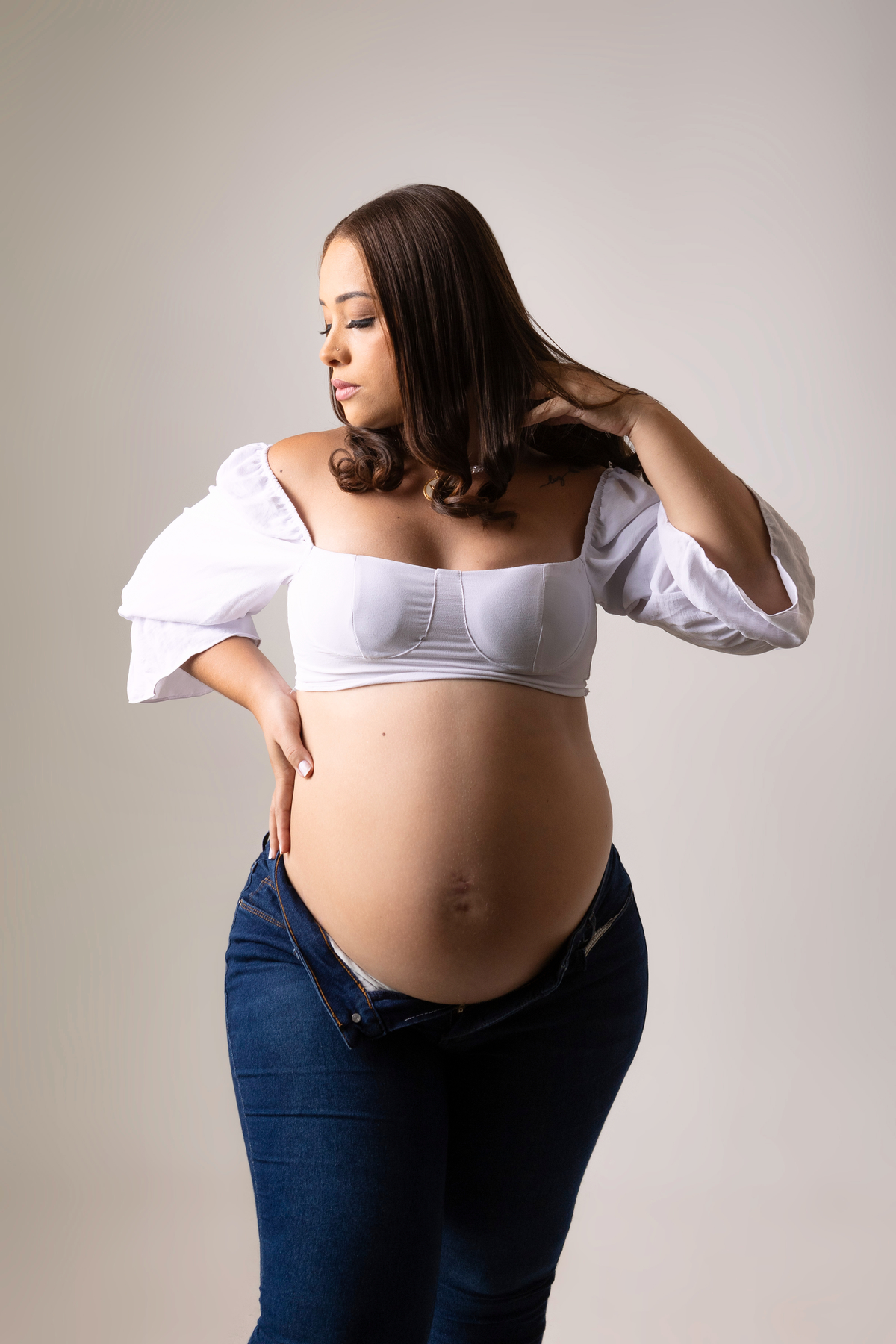 gestante com mão na cintura e outra no cabelo