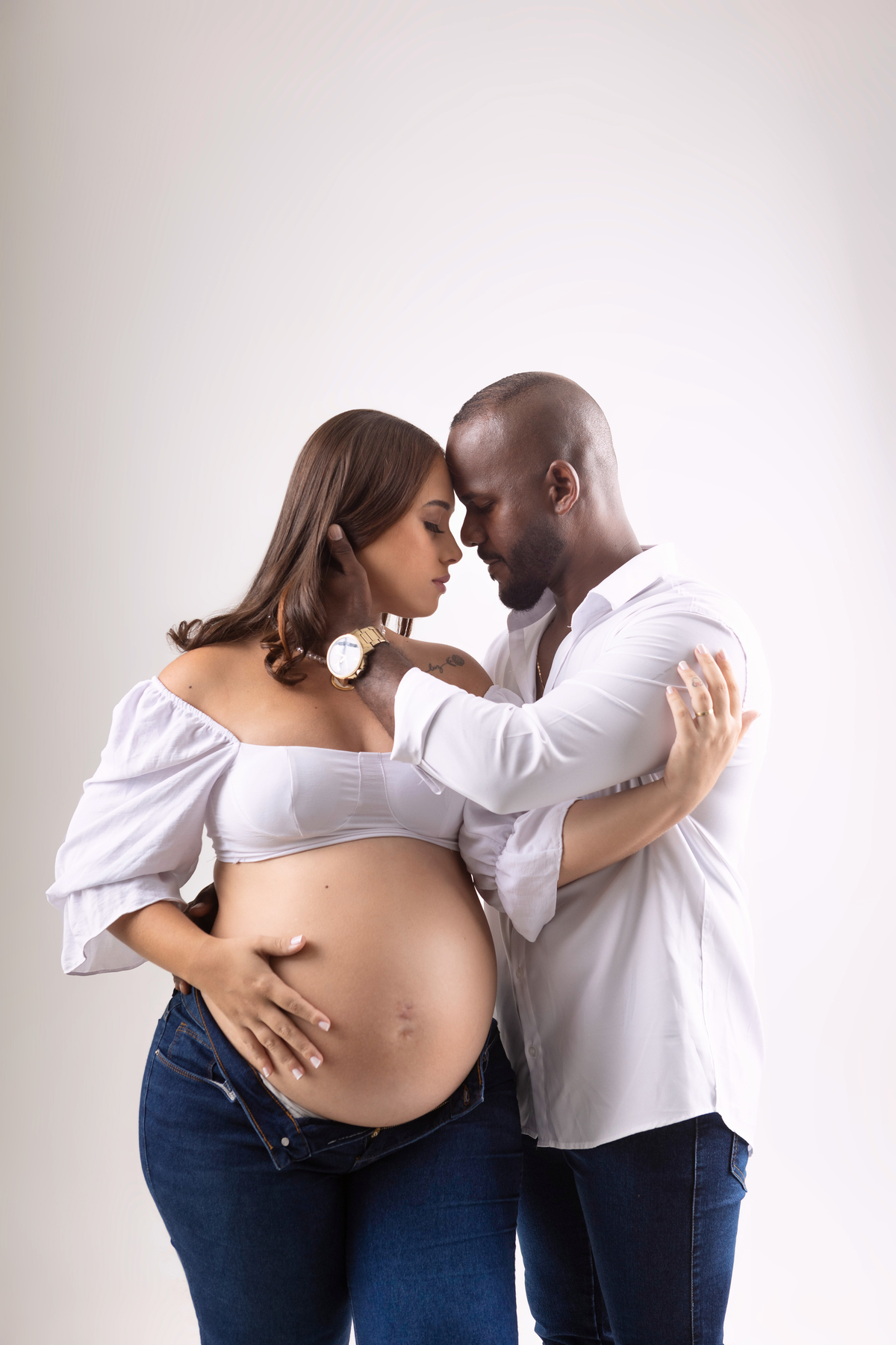 gestante tocando na barriga e abraçando papai