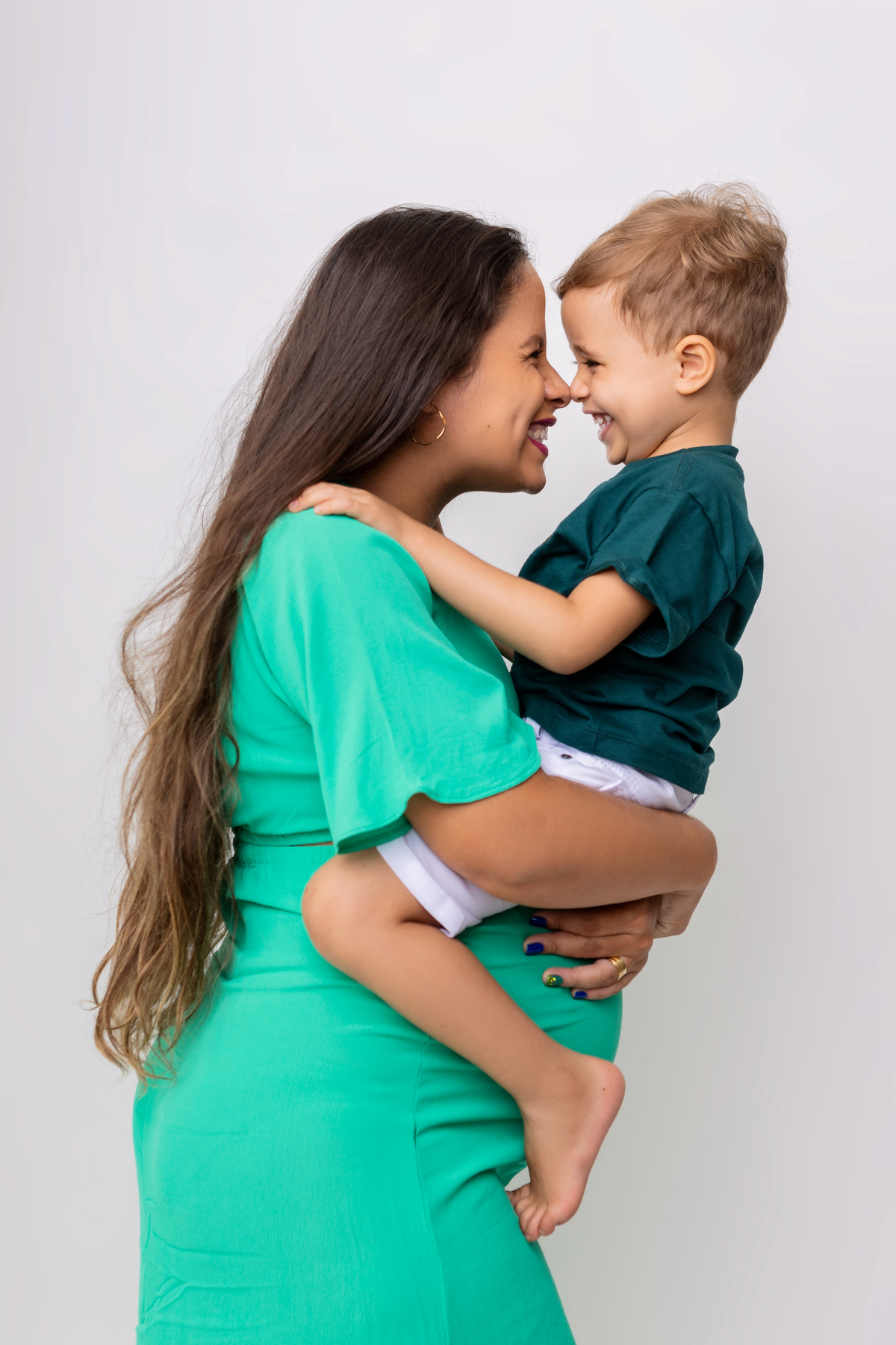gestante carregando seu filho e fazendo beijo esquimó