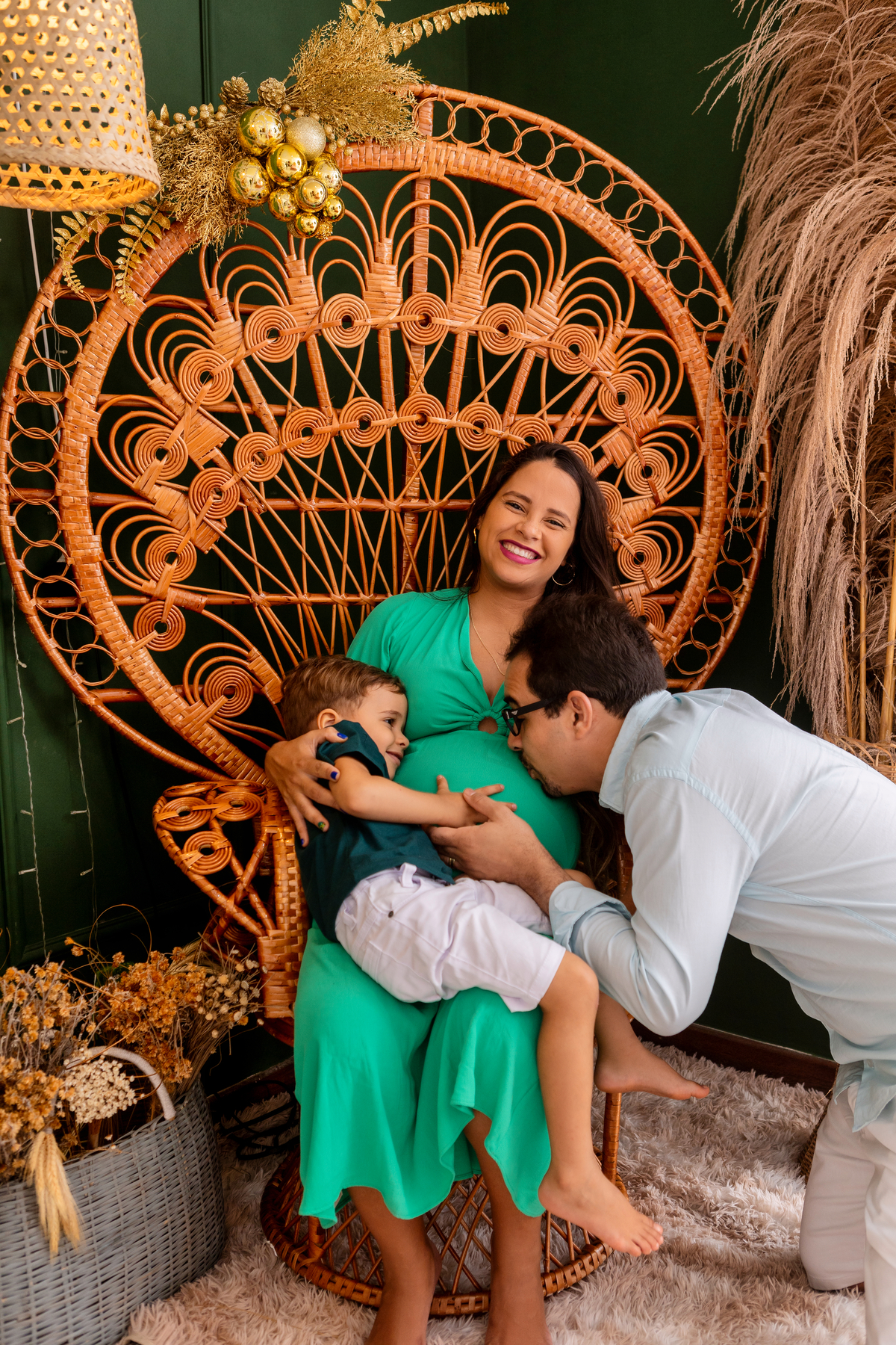 papai e filho beijando na barriga da gestante