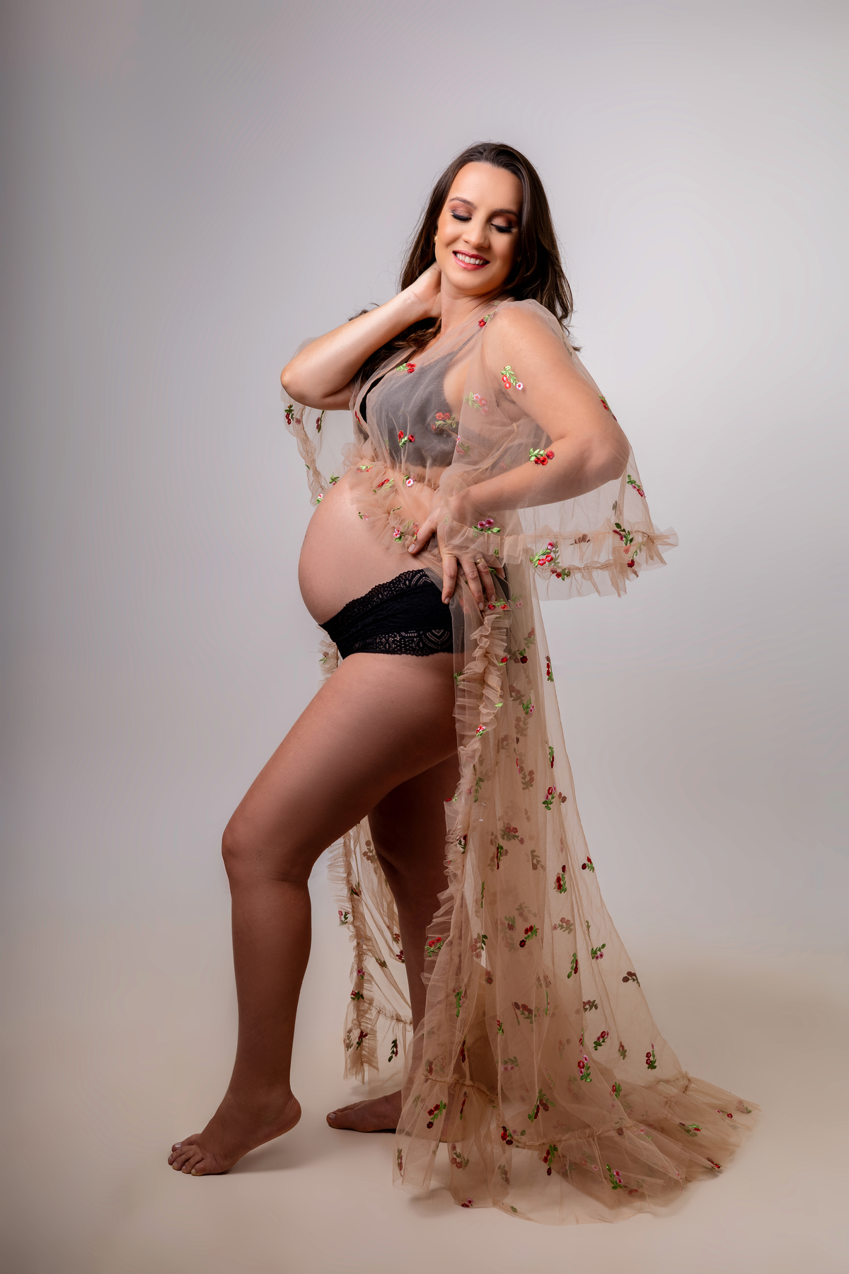 gestante com mão na cintura 
e outra no cabelo 