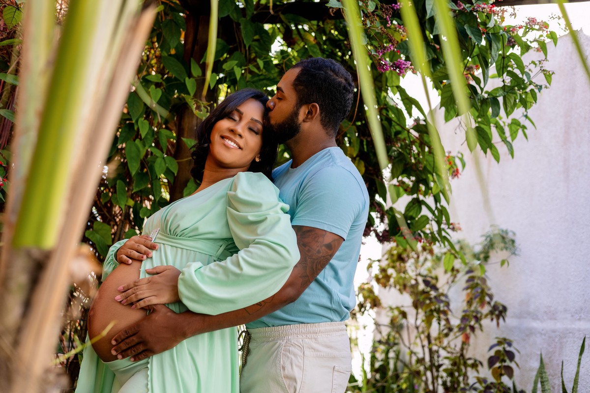 papai abraçando a barriga e beijando na testa da  gestante 