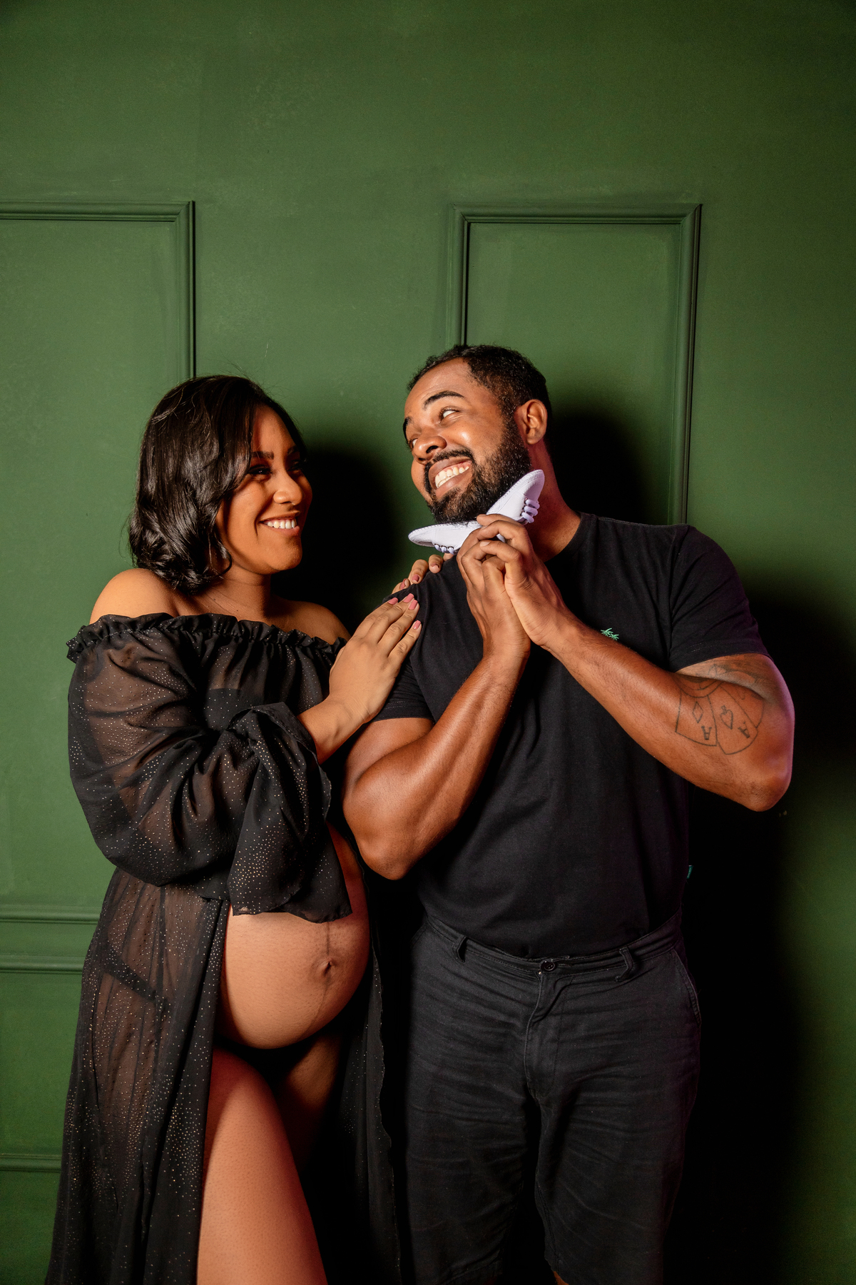 papai com sapatinho olhando para gestante