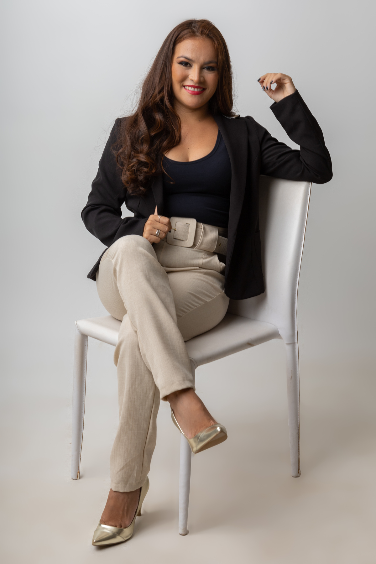 nail designer sentada segurando o blazer