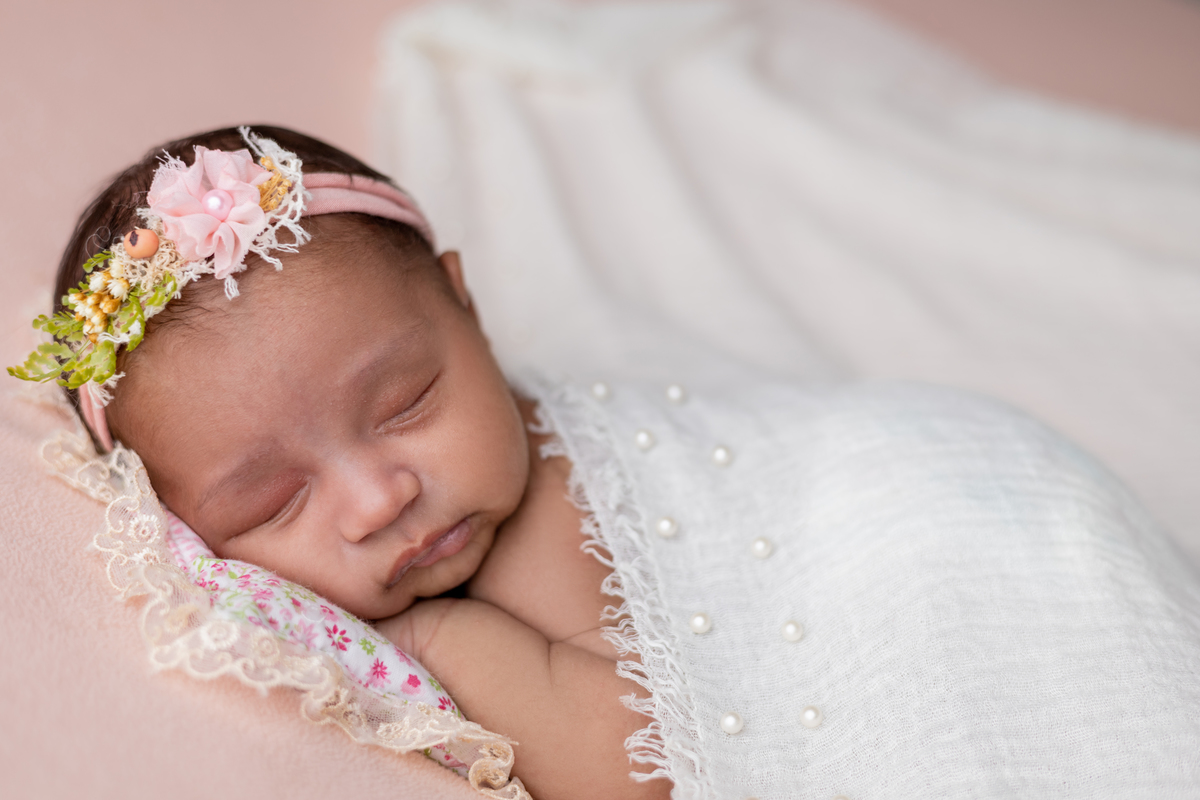 newborn coberta de bruços com tiara
