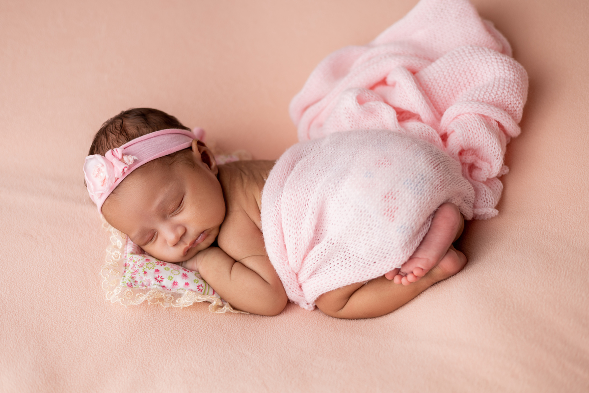 newborn coberta de bruços com tiara