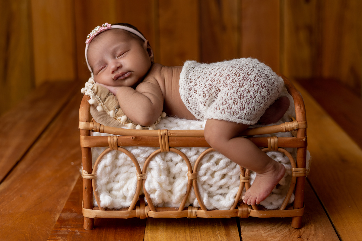 newborn de bruços coberto no props cama