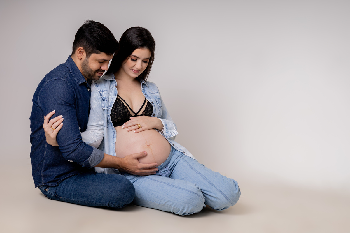 gestante e papai sentados tocando na barriga