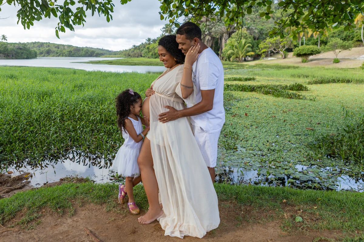gestante e papai vendo sua filha beijando na barriga