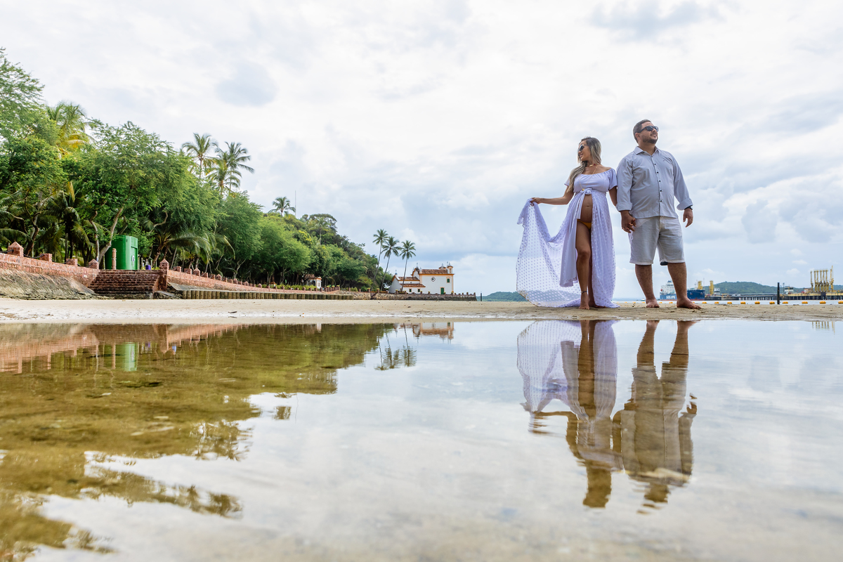 papai e gestante caminhando na beira do mar