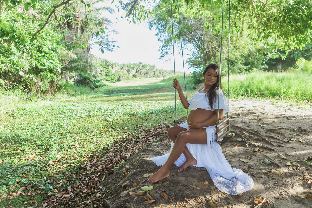 gestante sentada no balanço no campo