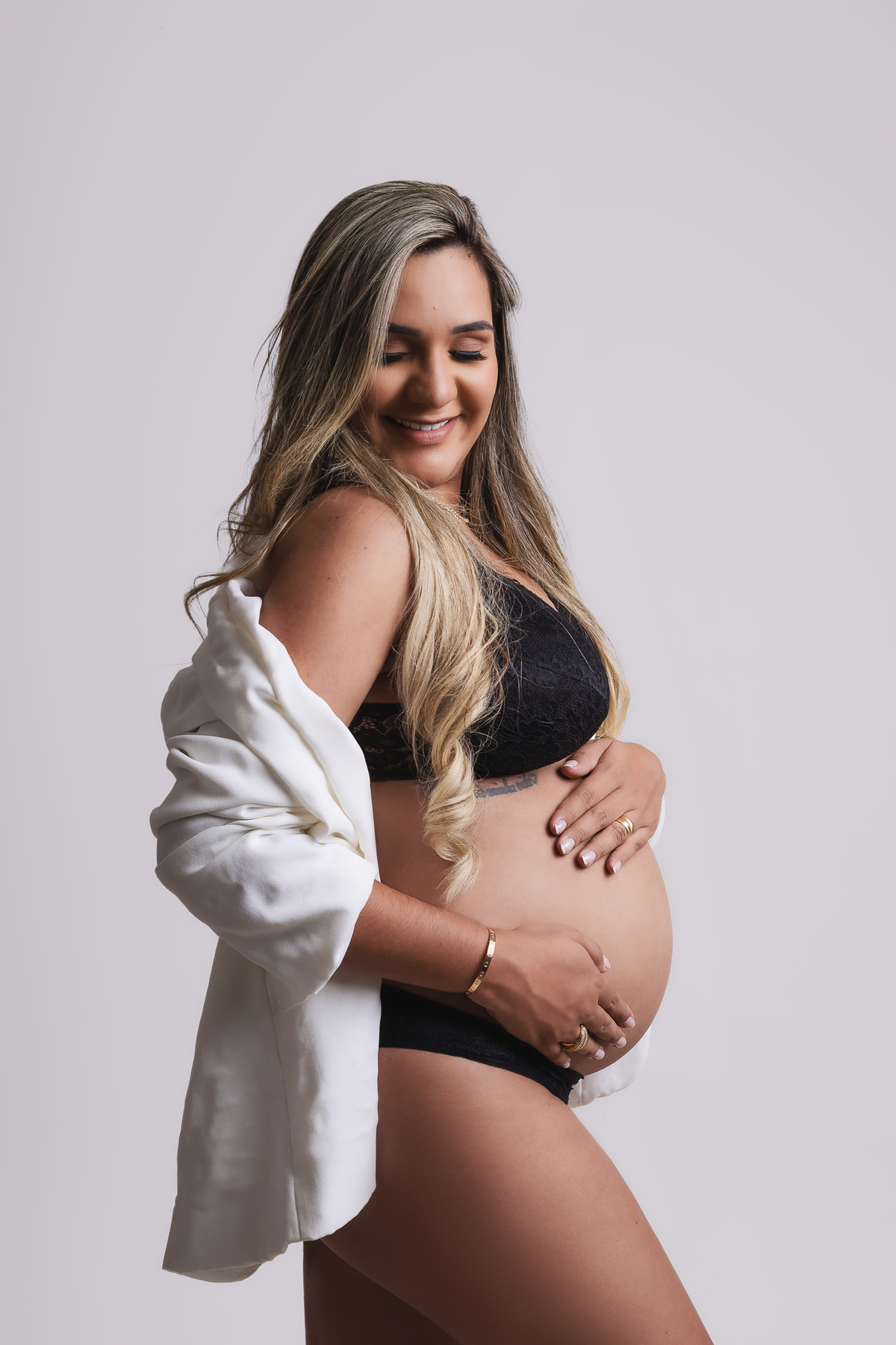 gestante com blazer tocando na barriga 