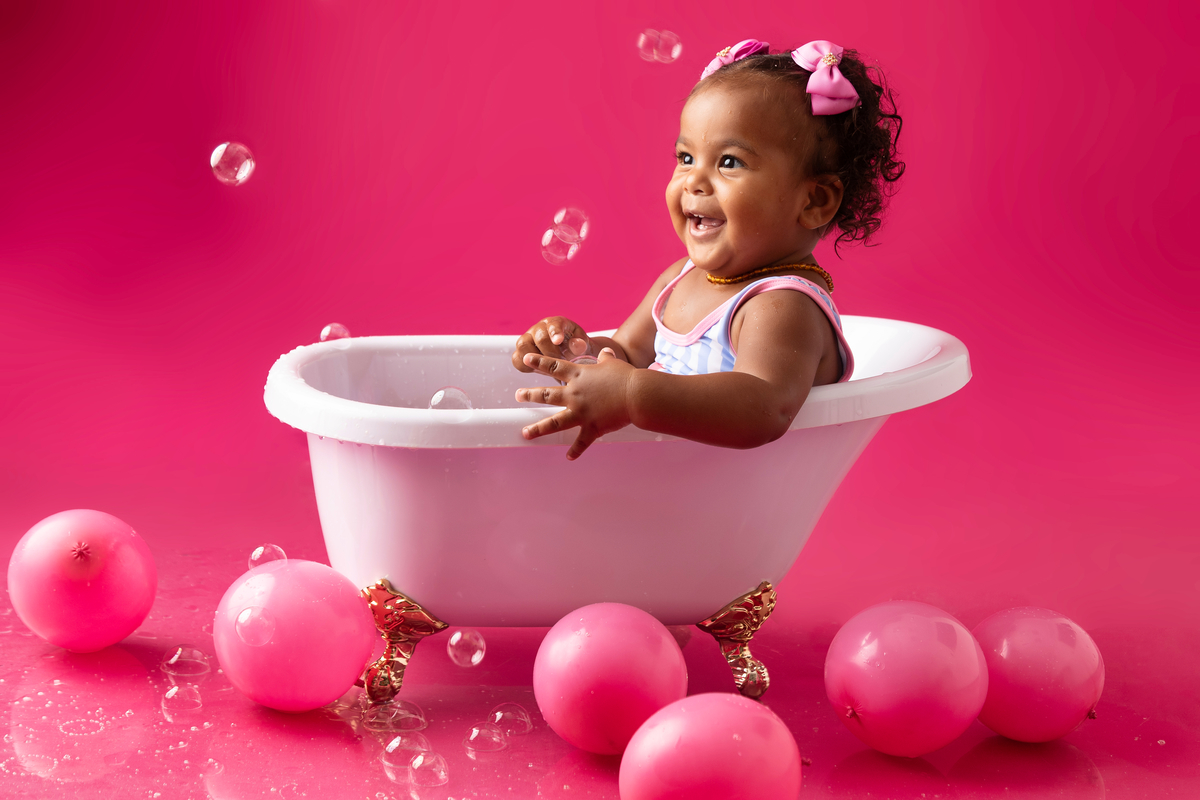 bebê sentada da banheira  com bolha de sabão