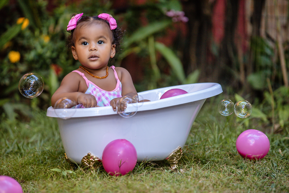 bebê sentada da banheira  com bolha de sabão