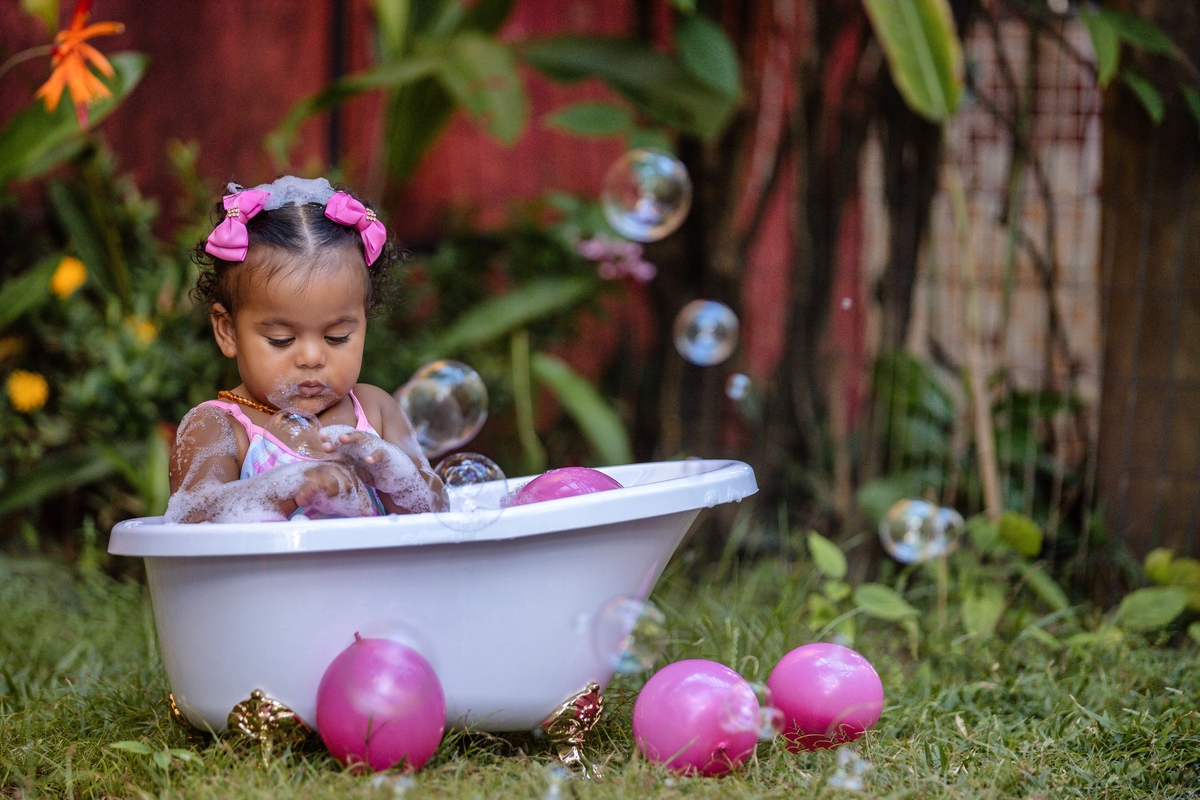 bebê sentada da banheira  com bolha de sabão