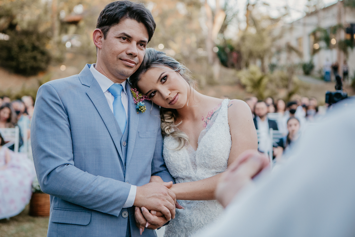Casal de noivos abraçados no altar