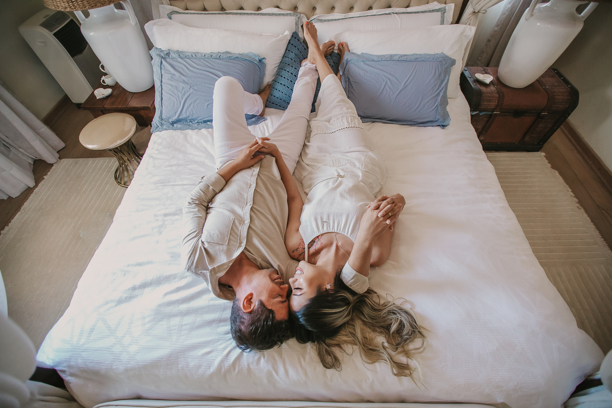 casal de noivos deitados na cama durante ensaio pre wedding