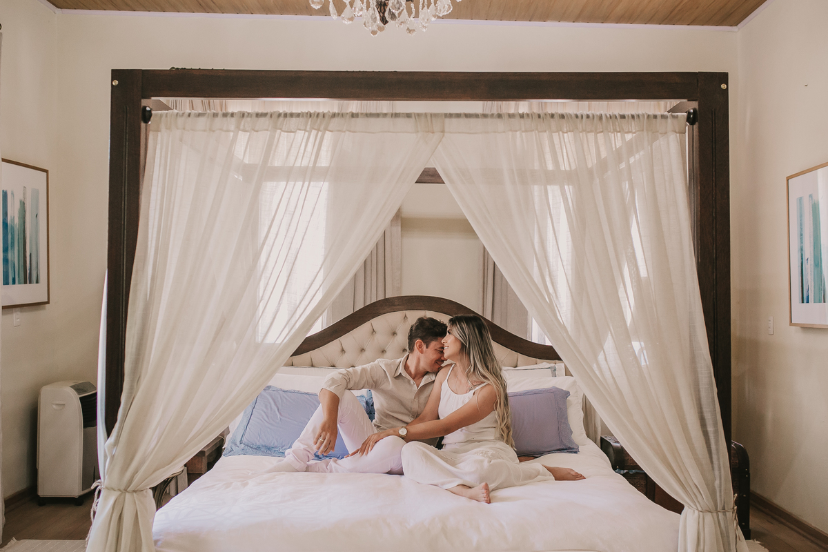 casal de noivos sentadosna cama durante ensaio pre wedding