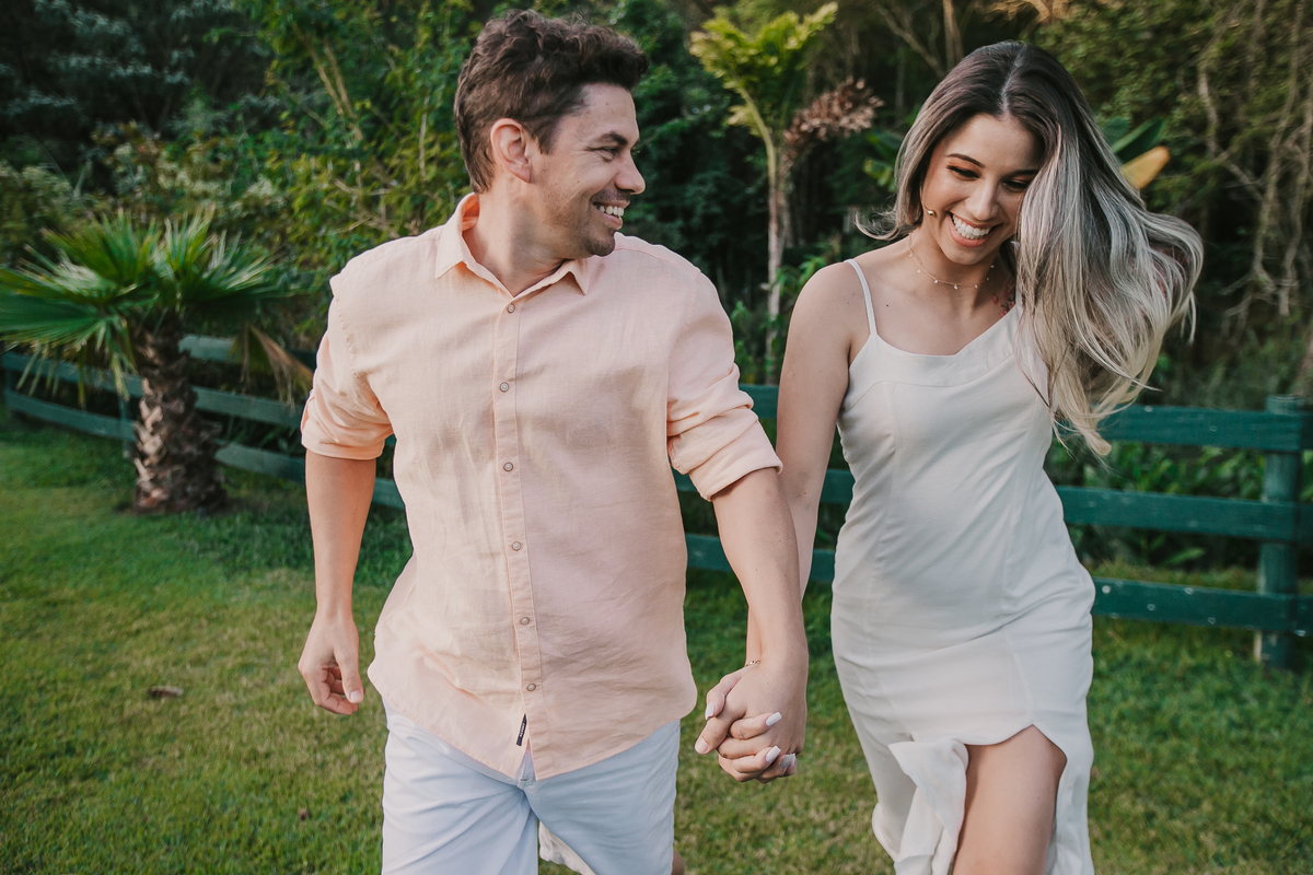 casal de noivos correndo durante fotos do ensaio pre-wedding na fazenda Dona Inês