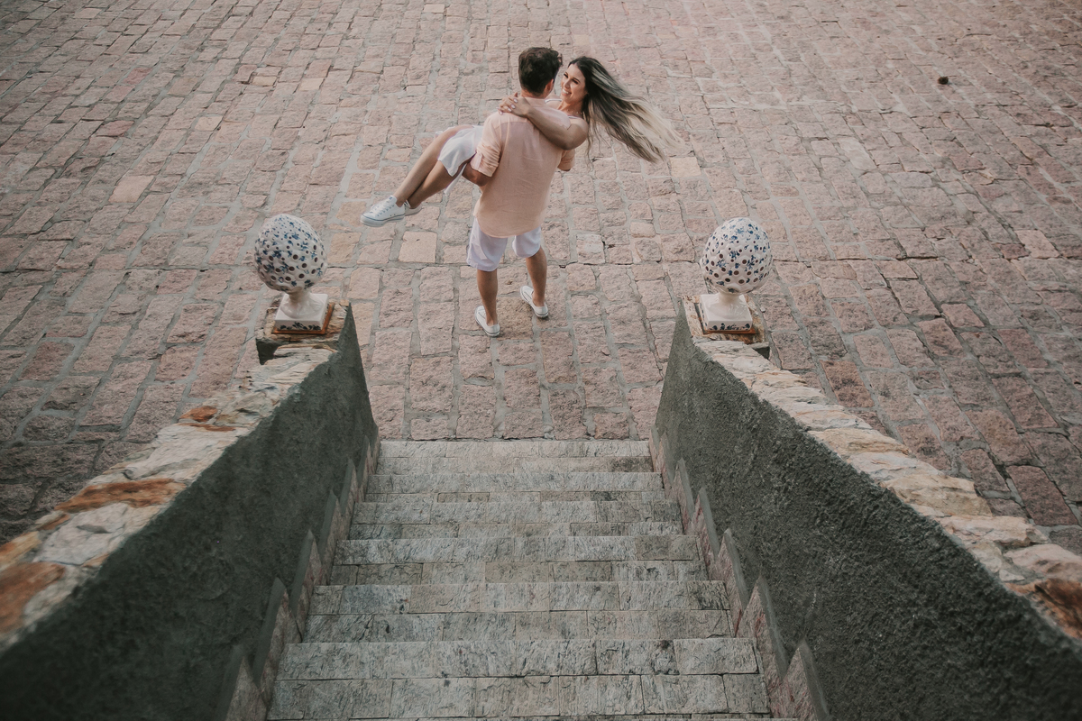 noiva no colo do noivo durante ensaio pre-wedding casal de noivos correndo durante fotos do ensaio pre-wedding na fazenda Dona Inês