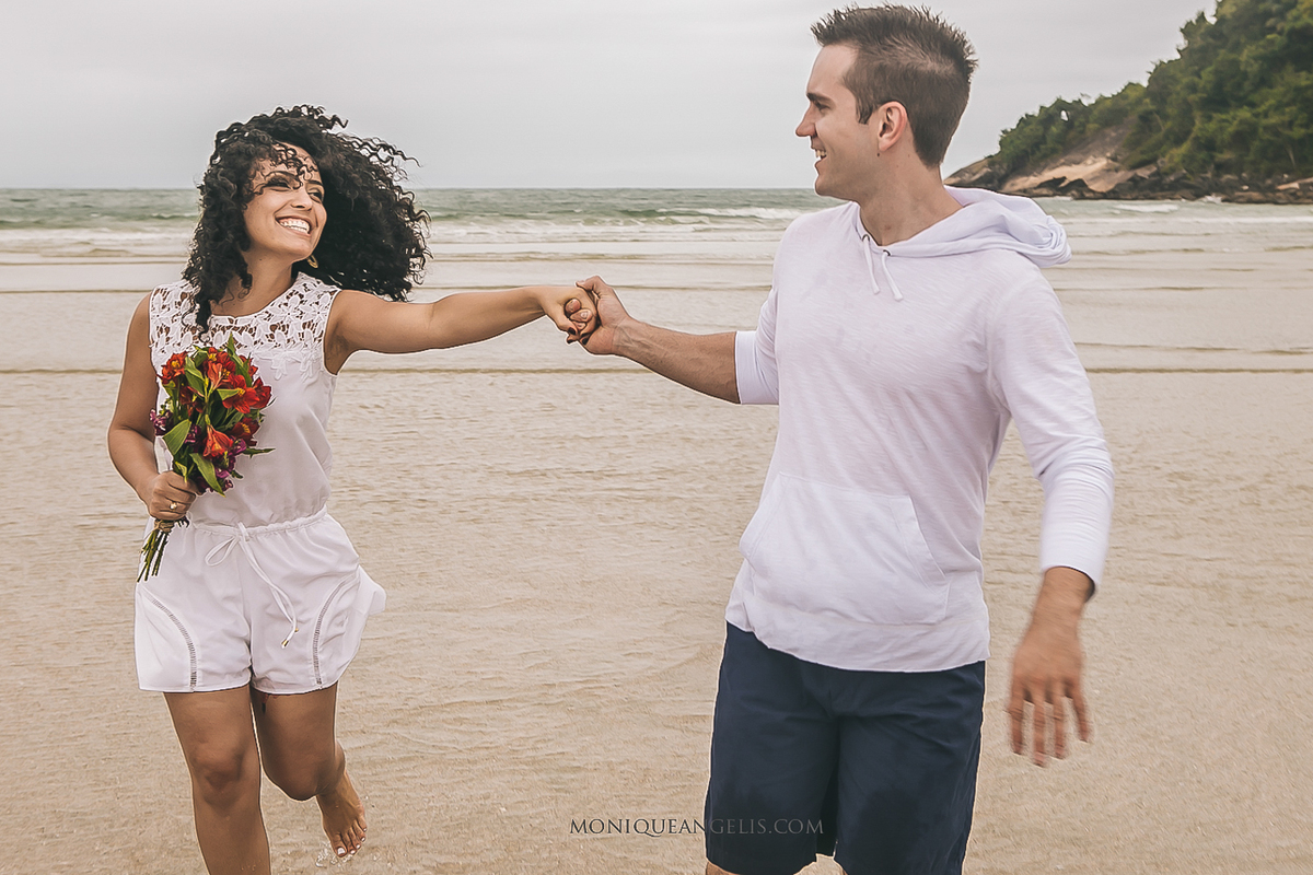 casal correndo na areia na praia do guarujá